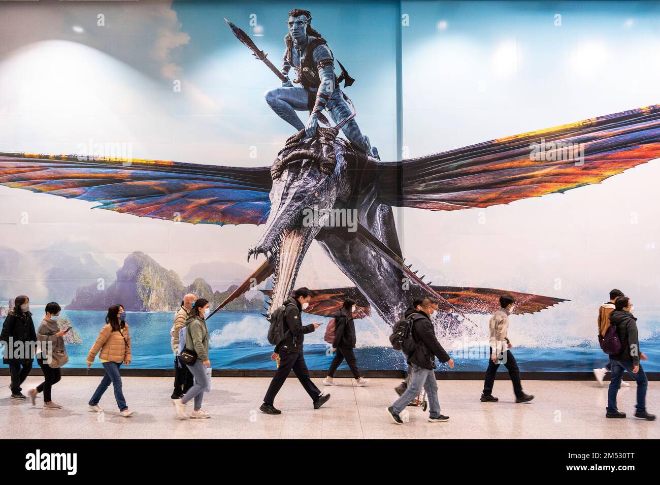 Hongkong, China. 24. Dezember 2022. Pendler gehen an einem großen Werbebanner vorbei, auf dem der Film Avatar: The Way of Water (Avatar 2) vorgestellt wird, der von Lightstorm Entertainment produziert und von 20. Century Studios in Hongkong vertrieben wird. Kredit: SOPA Images Limited/Alamy Live News Stockfoto