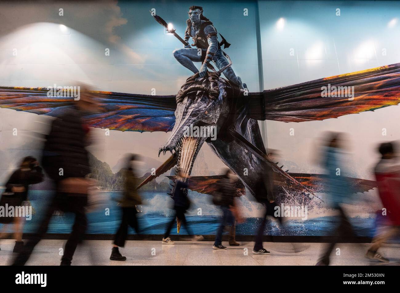 Hongkong, China. 24. Dezember 2022. Pendler gehen an einem großen Werbebanner vorbei, auf dem der Film Avatar: The Way of Water (Avatar 2) vorgestellt wird, der von Lightstorm Entertainment produziert und von 20. Century Studios in Hongkong vertrieben wird. (Foto: Sebastian Ng/SOPA Images/Sipa USA) Guthaben: SIPA USA/Alamy Live News Stockfoto