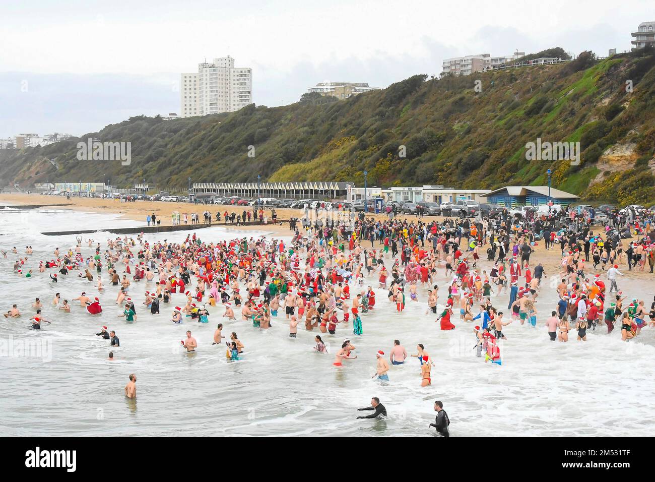 Boscombe, Dorset, Großbritannien. 25. Dezember 2022 Wetter in Großbritannien. Hunderte Weihnachtsfeier in festlichem Kostüm tauchen im Boscombe in Bournemouth in Dorset ins kalte Meer ein, um an einem kalten, bedeckten Morgen im Macmillan White Christmas Dip zu schwimmen. Bildnachweis: Graham Hunt/Alamy Live News Stockfoto