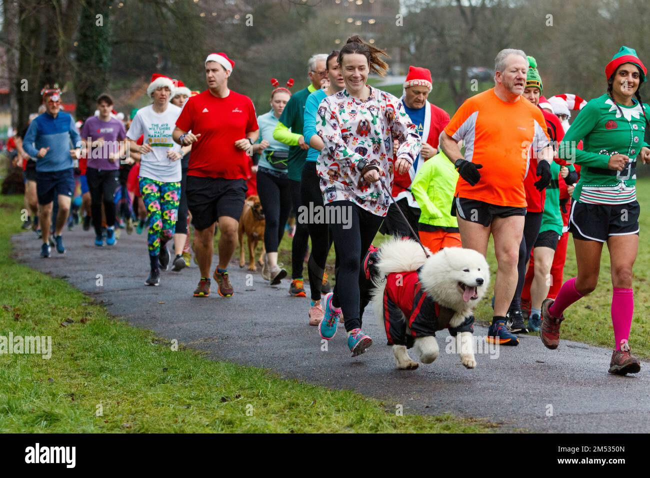 Chippenham, Wiltshire, Großbritannien. 25. Dezember 2022. Die Läufer nehmen am ersten Weihnachtsmorgen an einem 5km Park Run in Monkton Park, Chippenham, Wiltshire, Teil. Das feuchte Wetter hat die Stimmung der 200-300 Personen, die an der Veranstaltung teilgenommen haben, nicht geschwächt, viele von ihnen haben sich in schicken Kleidern verkleidet. Kredit: Lynchpics/Alamy Live News Stockfoto