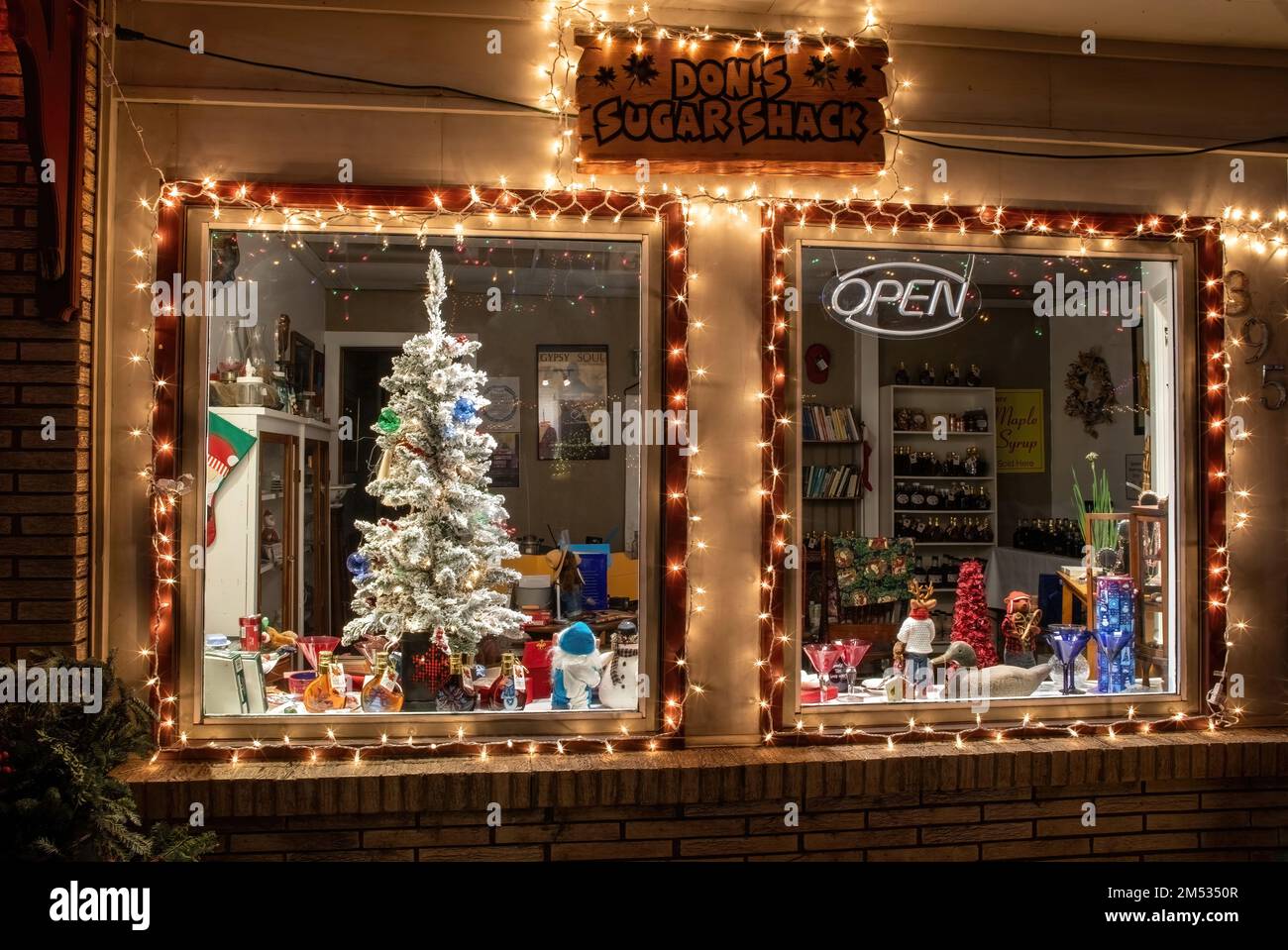 Das schöne beleuchtete Weihnachtsfenster in Don's Sugar Shack in Taylors Falls, Minnesota, USA. Sie verkaufen hausgemachten Ahornsirup. Stockfoto