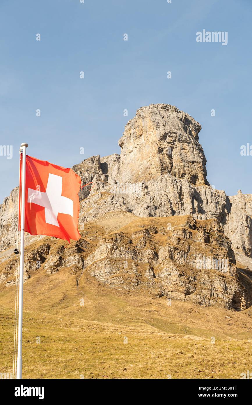 Klausenpass, Uri, Schweiz, 29. Oktober 2022 Schweizer Flagge winkt im Wind vor einer unglaublichen Gebirgsformation Stockfoto