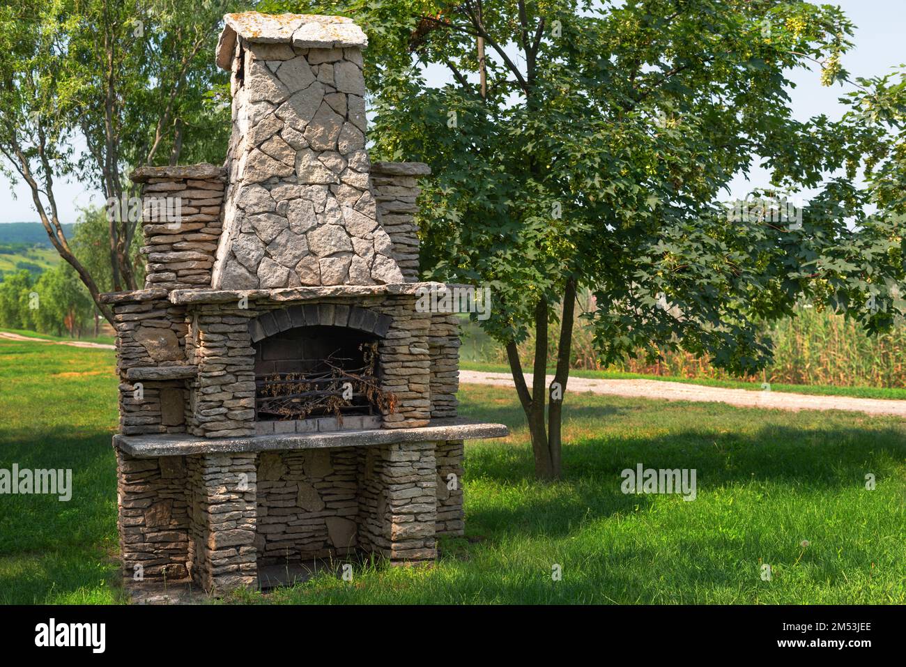 Ein Steingartenofen zum Grillen oder Grillen befindet sich in einem Hinterhof. Stockfoto