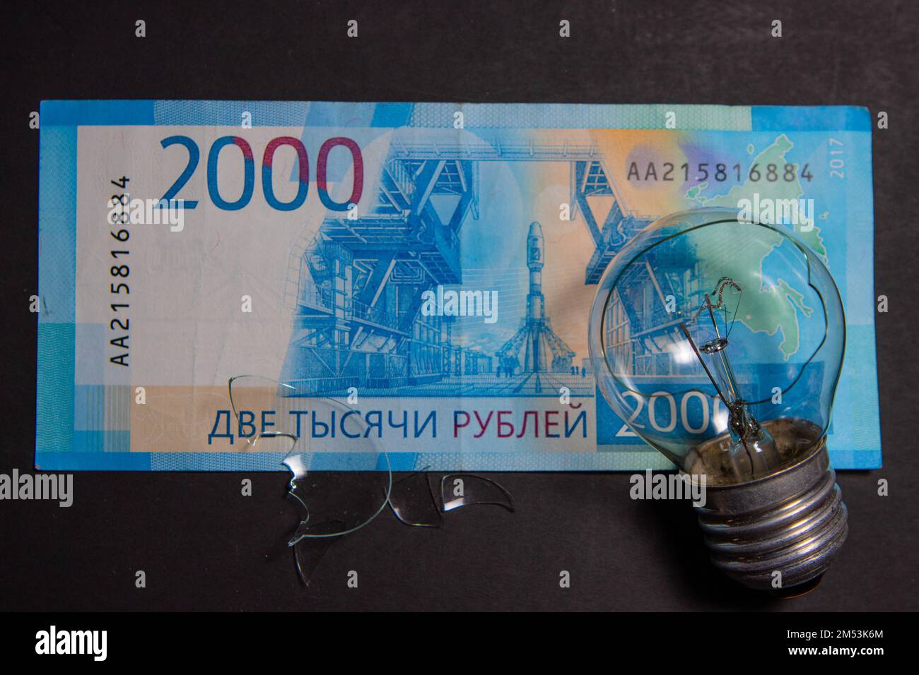 Kaputte Glühbirne mit Glasscherben auf russischem Rubel. Konzept der Strompreise und die Stromversorgungskrise in Russland Stockfoto
