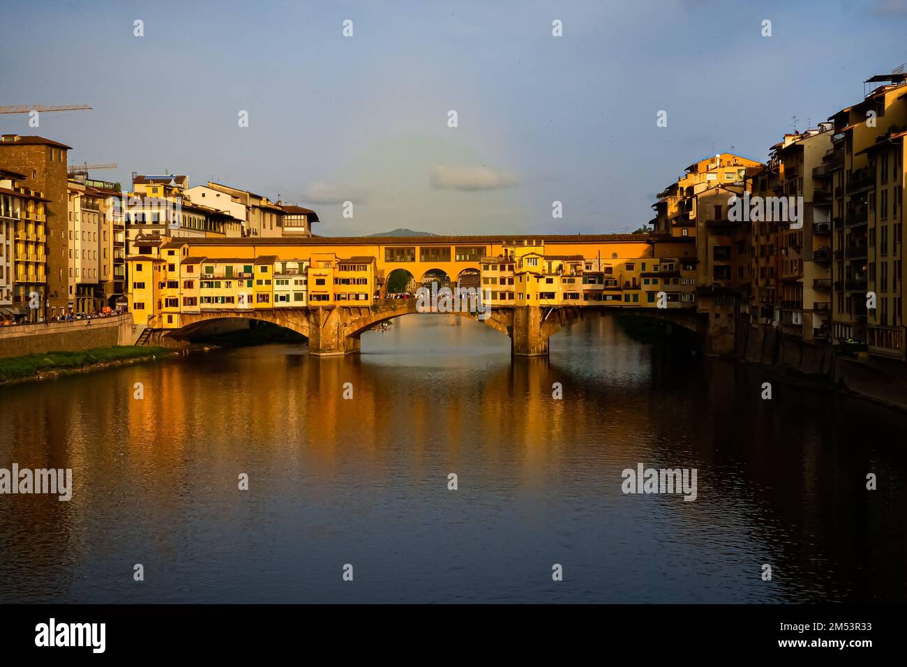 Die Ponte Vecchio Spandrel Bogenbrücke auf dem Wasser in Florenz, Italien, unter dem violetten Sonnenuntergangshimmel Stockfoto