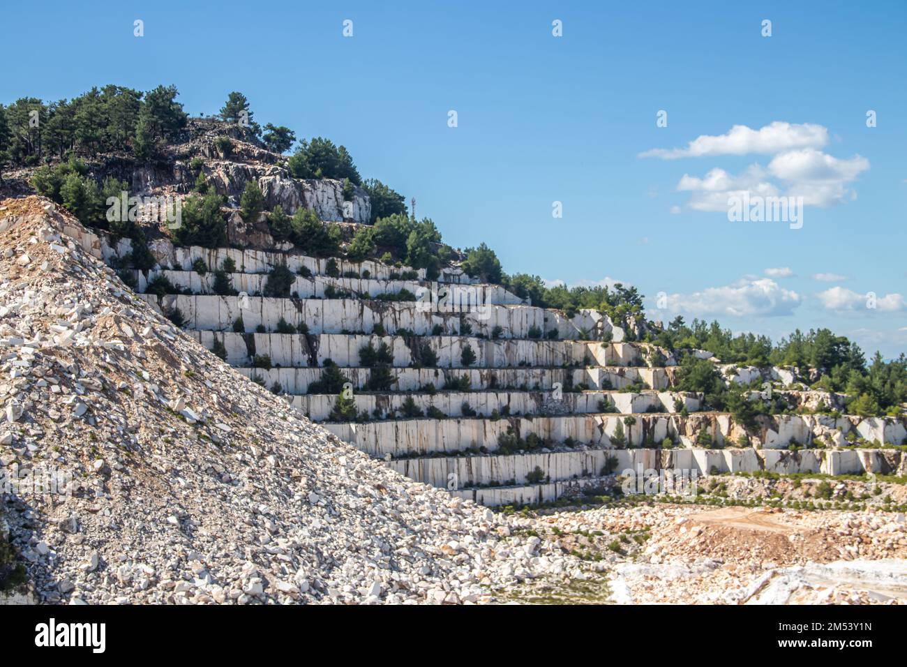 Eine offene Grube aus weißem Marmorstein mit schweren Maschinen, mit denen der Edelstein zur weiteren Verwendung und Produktion abgebaut und abgebaut wird Stockfoto