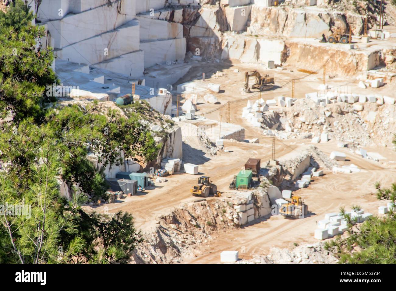 Eine offene Grube aus weißem Marmorstein mit schweren Maschinen, mit denen der Edelstein zur weiteren Verwendung und Produktion abgebaut und abgebaut wird Stockfoto