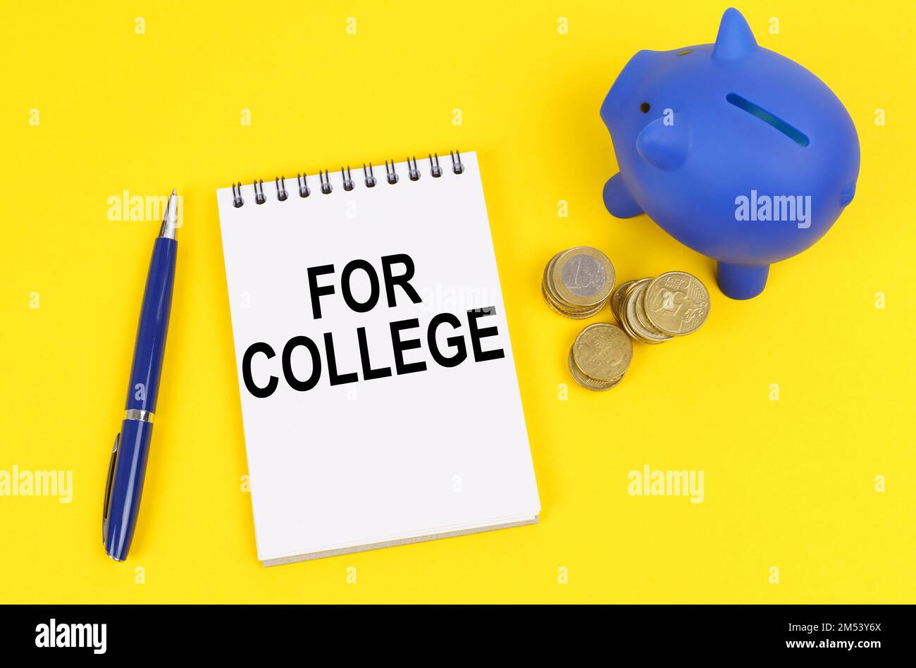 Geschäfts- und Finanzkonzept. Auf einer gelben Oberfläche, einem Sparschwein, Münzen und einem Notizblock mit der Inschrift für das College Stockfoto
