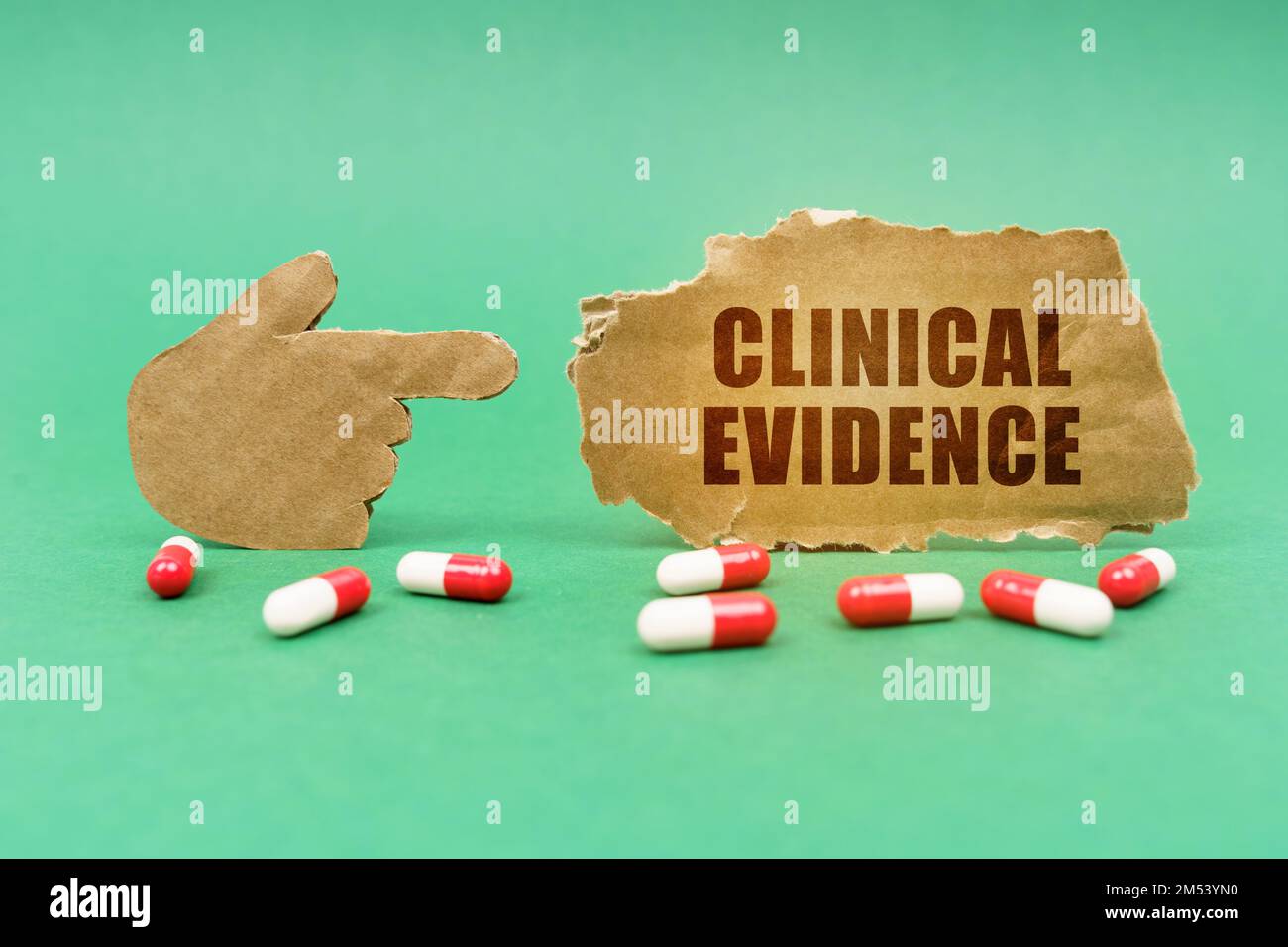 Medizinisches Konzept. Auf der grünen Oberfläche der Tablette und einer Hand, die auf ein Schild mit der Inschrift zeigt - Klinische Evidenz Stockfoto