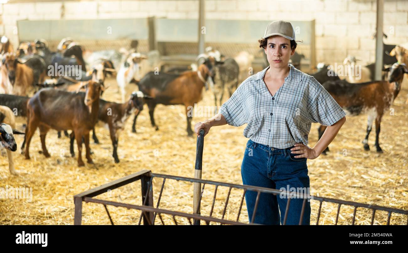 Selbstbewusste lateinamerikanische Bauernfrau, die im Ziegenstall posiert Stockfoto