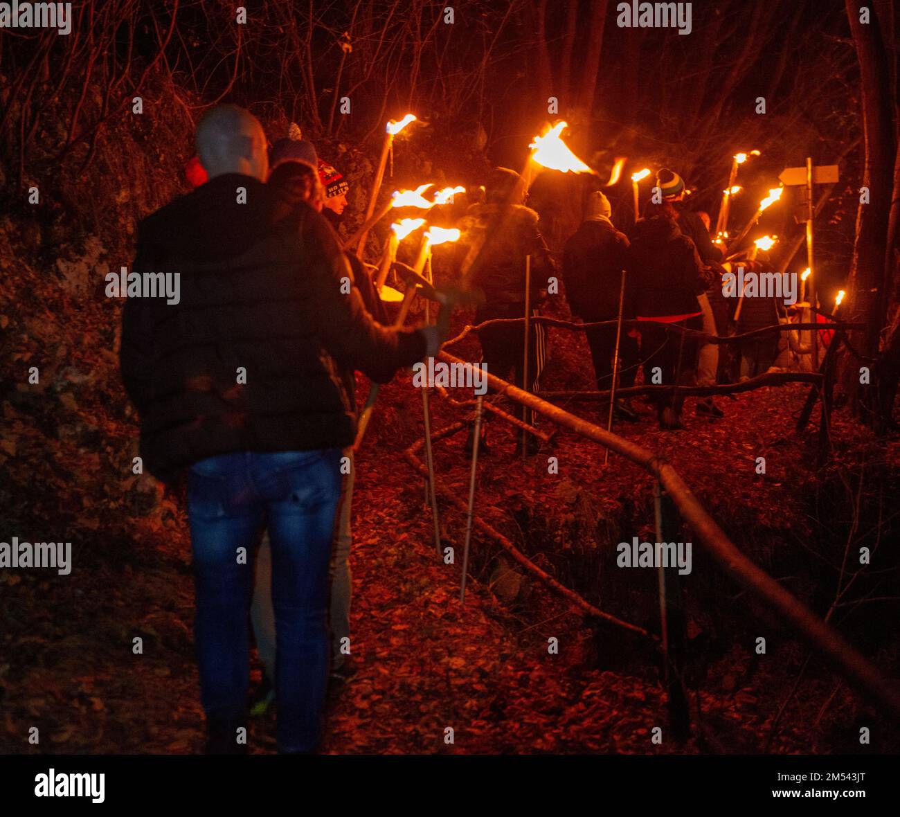 Serina Italien Dezember 24 2022: Menschen mit Fackeln gehen auf die Hütte zu, um den weihnachtstag zu feiern Stockfoto