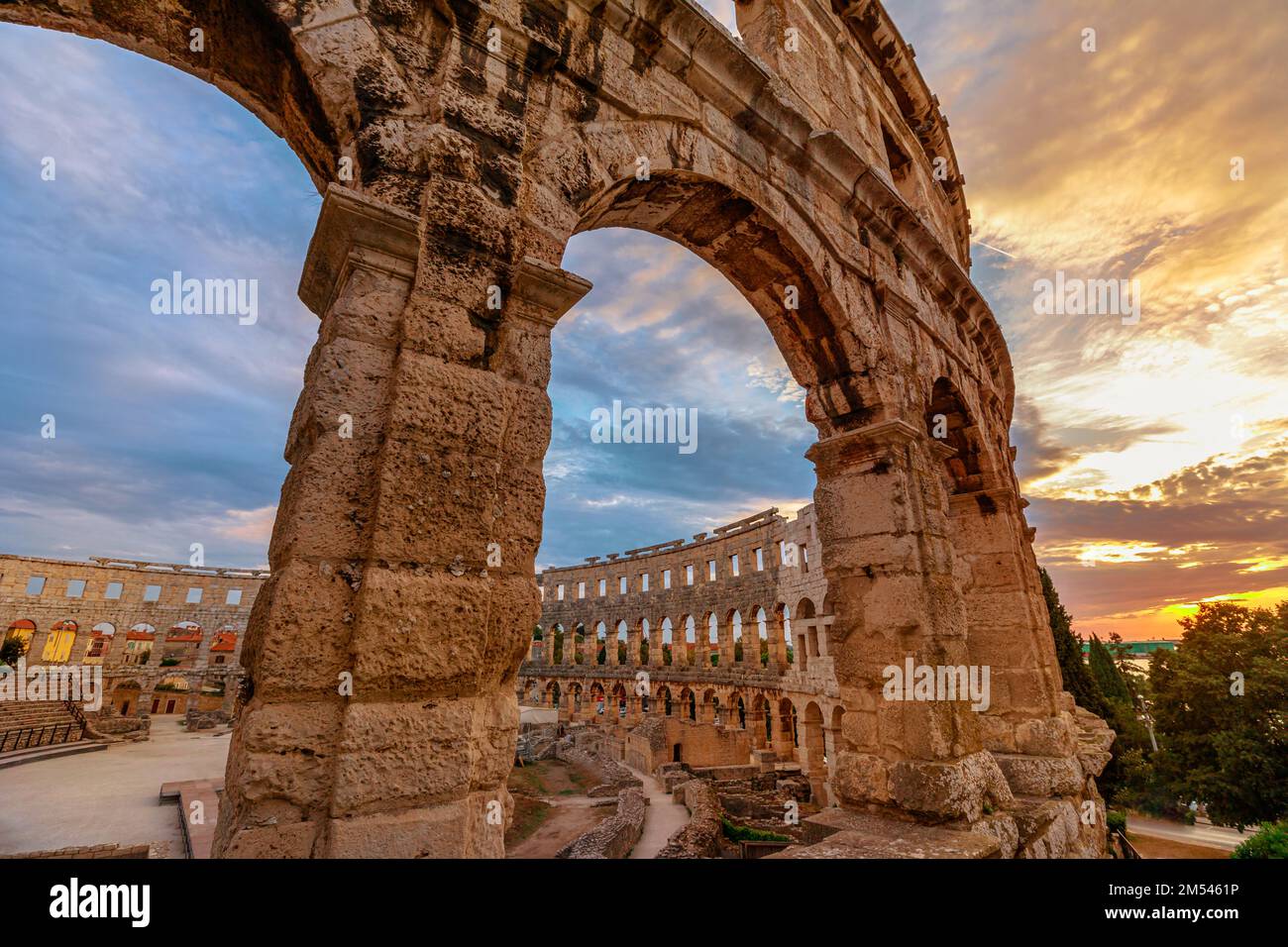 Das Pula Amphitheater in Istrien, Kroatien im Laufe des Abends verwandelt sich der Himmel in einen atemberaubenden Pink- und Orangenton und schafft eine atemberaubende Kulisse Stockfoto