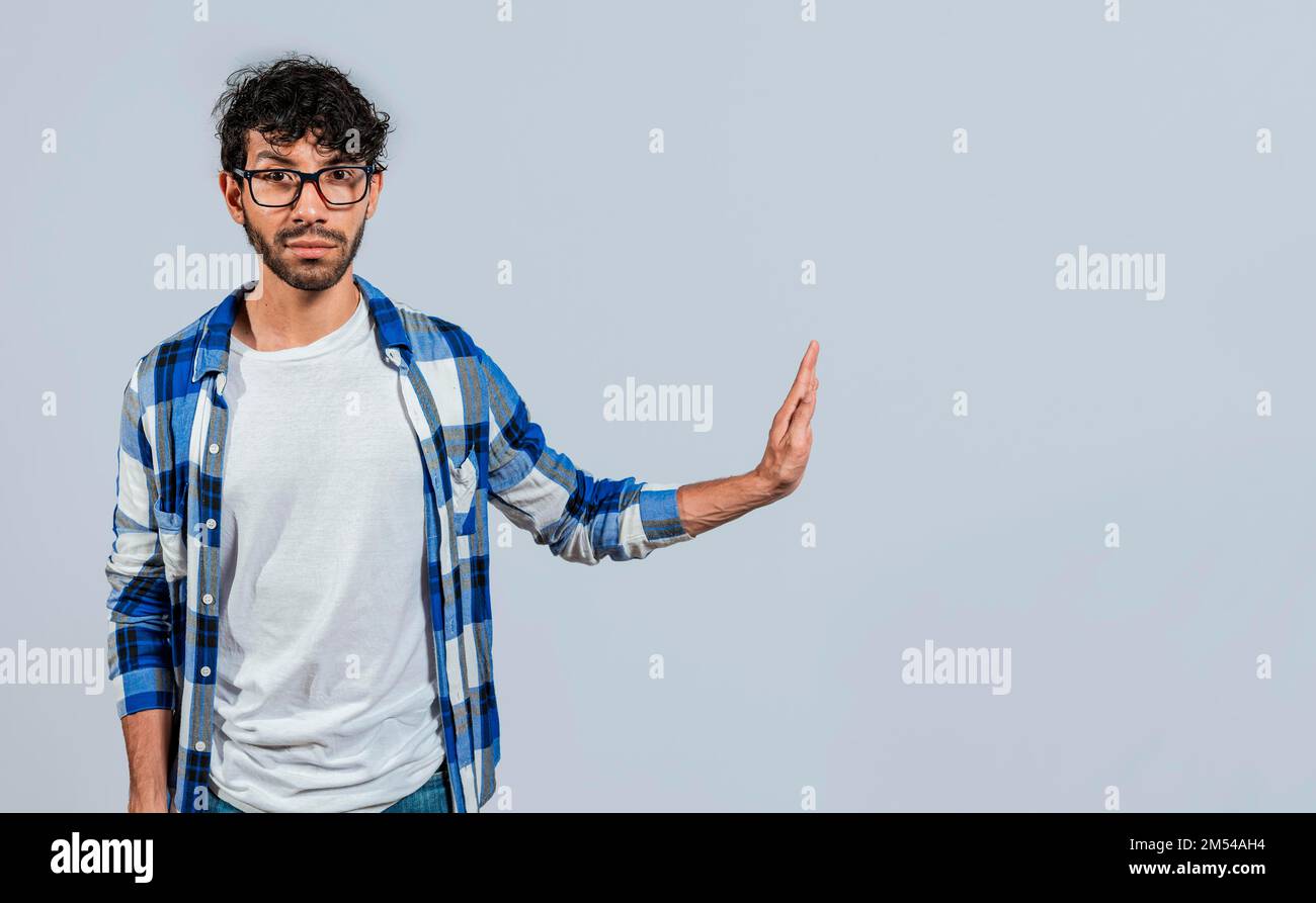 Verärgerter junger Mann, der mit Abstoßungsgeste abweist, mit isolierten Handflächen werfen. Unzufriedene Person mit isolierter Abstoßungsgeste zieht Handflächen ein Stockfoto