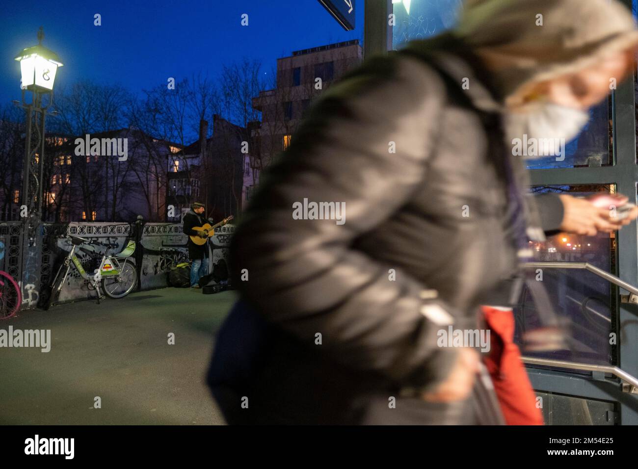 Deutschland, Berlin, 15. 03. 2020, Straßenmusiker, Gitarrist, Mnemonik, Greifenhagener Straße, S-Bahn-Station, Frau mit Mundschutz Stockfoto