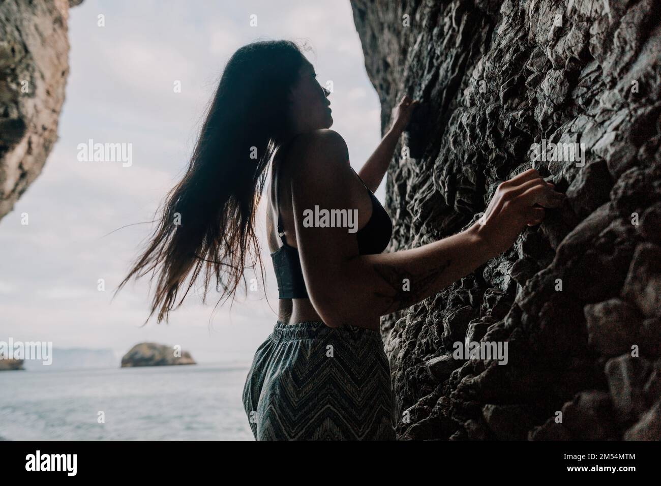 Sportlerin Klettert Auf Den Felsen. Junge Frau mit schlanker Passform Körper c Stockfoto