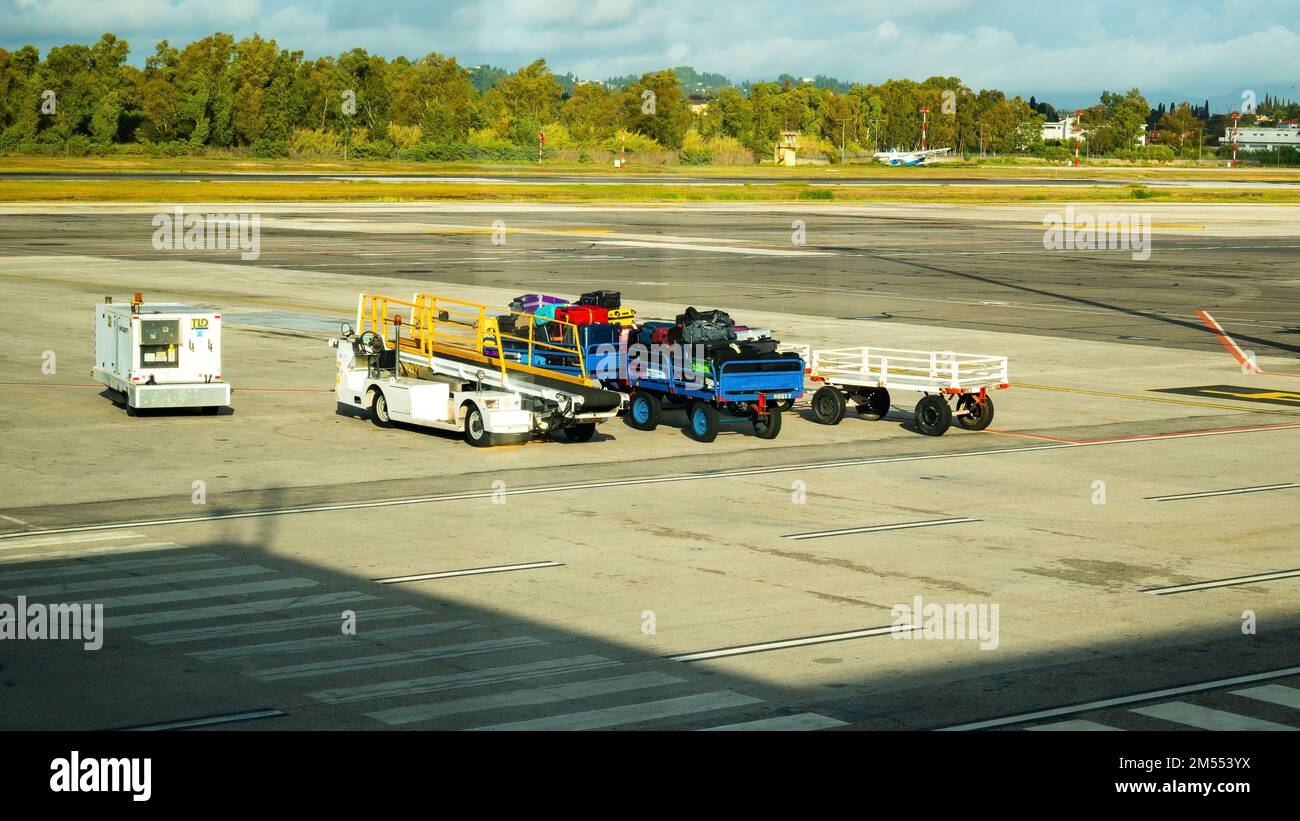 Kerkyra, Griechenland - 09 29 2022: Blick auf den Flughafen Korfu auf leere und beladene Wagen mit Gepäck bei sonnigem Wetter. Stockfoto