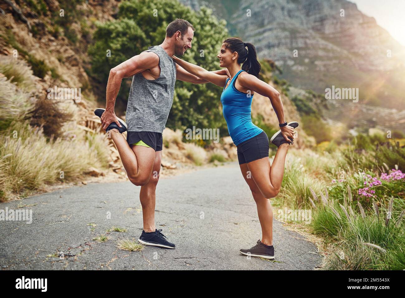 Wir helfen uns gegenseitig. Ein junges, attraktives Paar, das für einen Marathon im Freien trainiert. Stockfoto