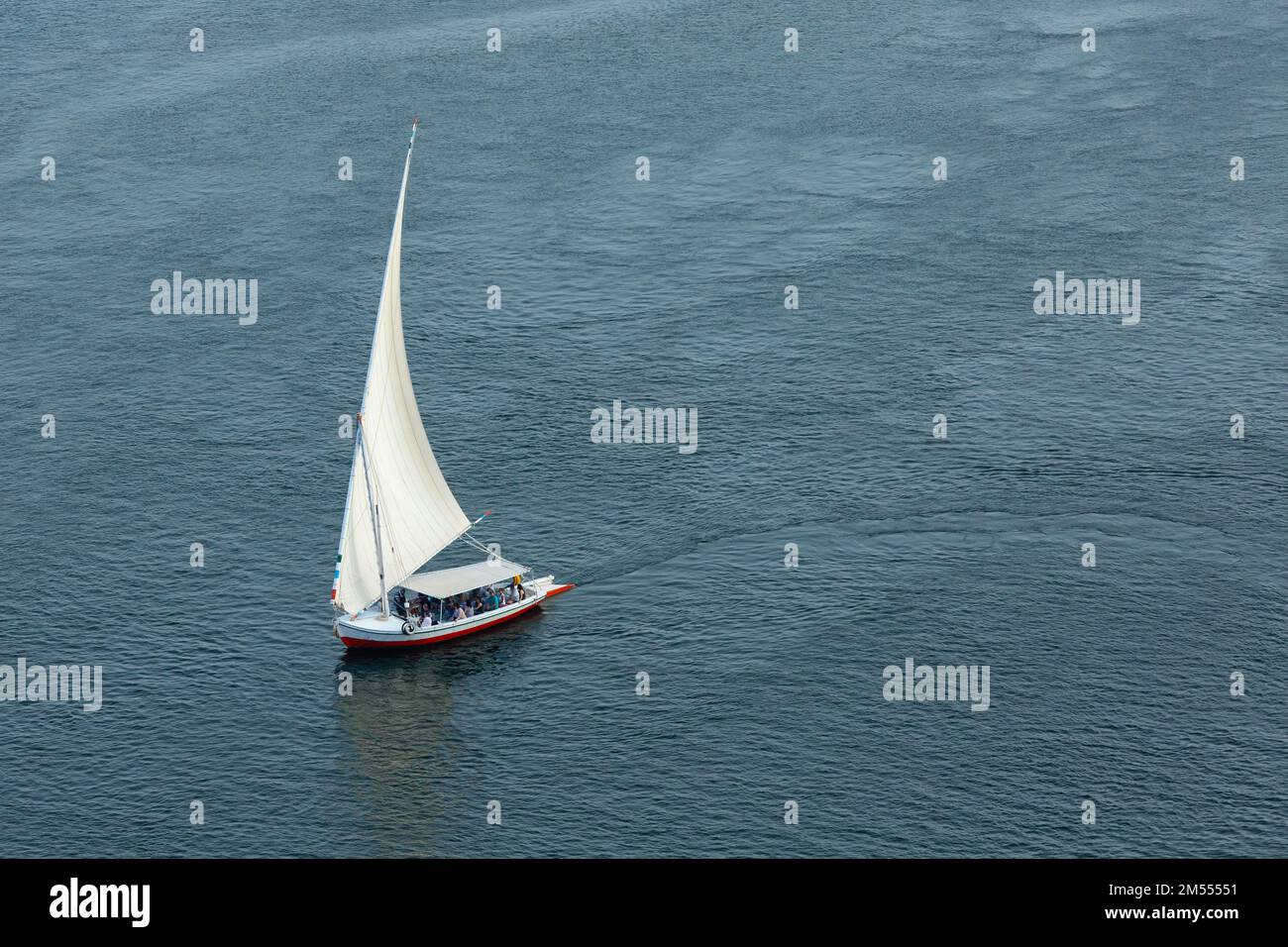 (Flussschiff) Feluke auf dem Nil mit der Sahara hinter in Assuan, Egipt. Stockfoto