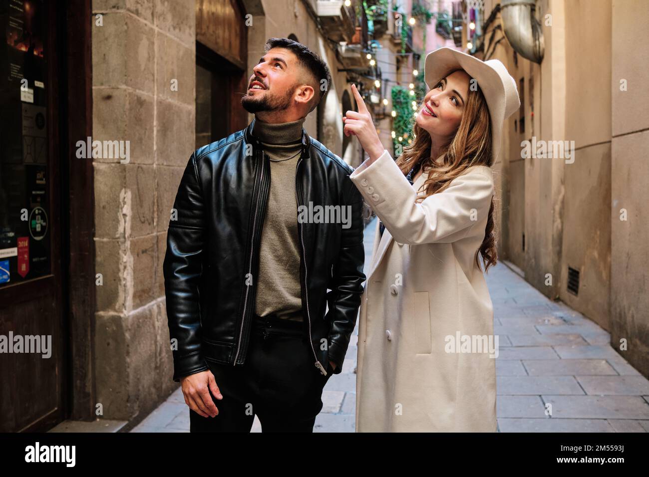Ein Paar, das eine Stadt besucht, während es auf ein Gebäude zeigt Stockfoto