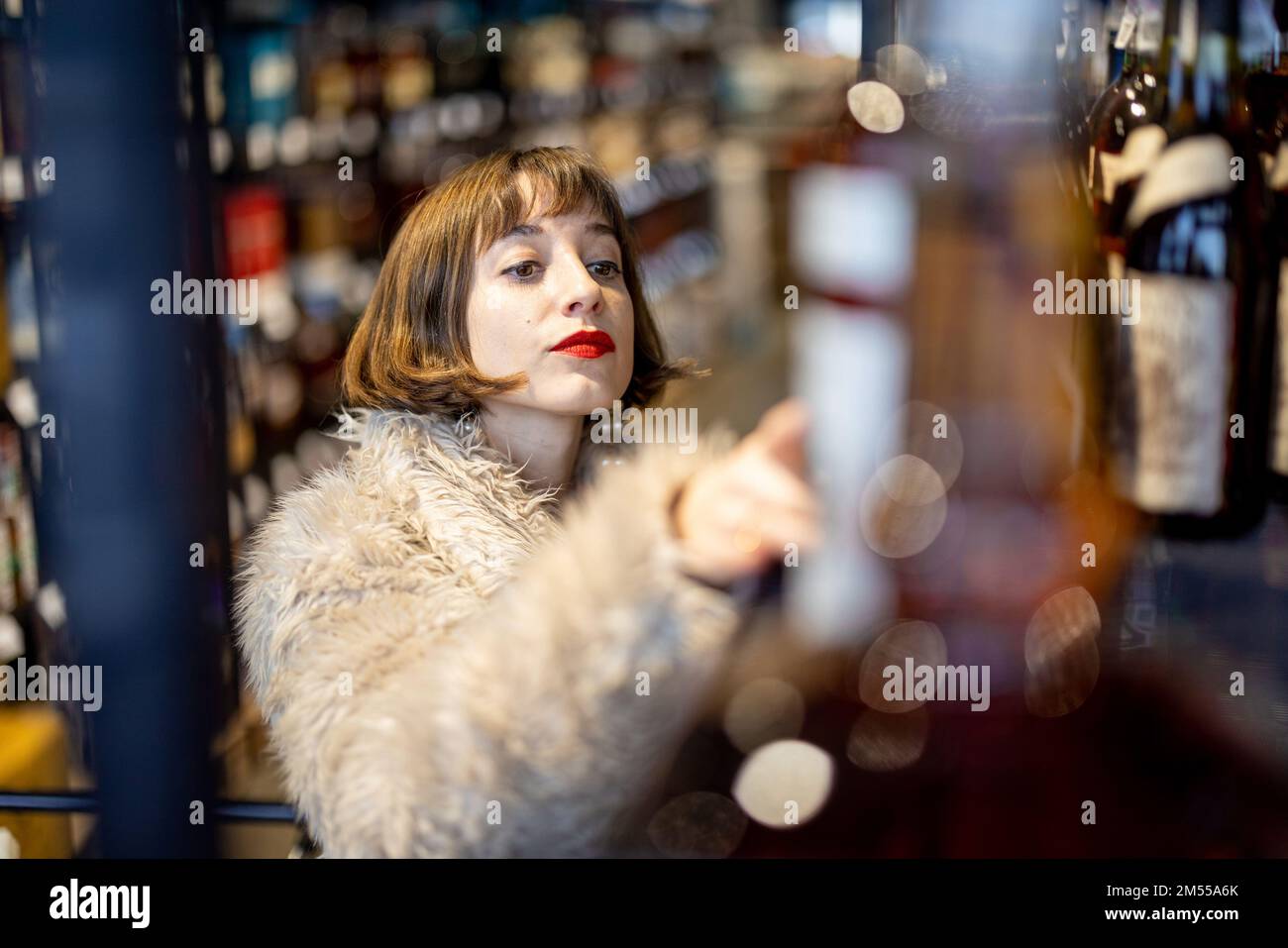 Frau wählt starken Alkohol im Supermarkt Stockfoto