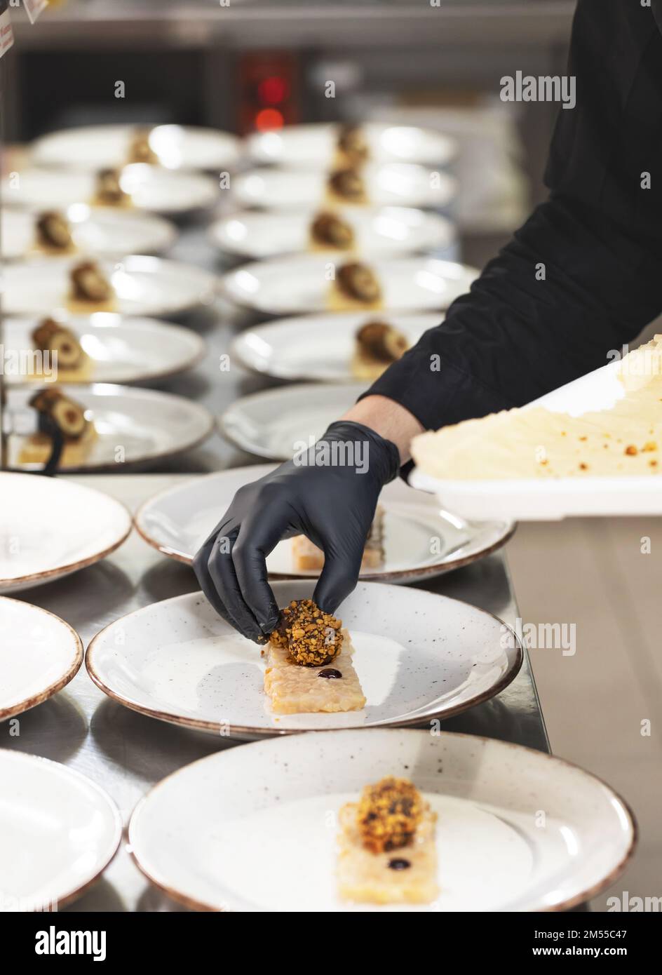 Koch bereitet Vorspeisen auf einer kommerziellen Küchentheke zu Stockfoto