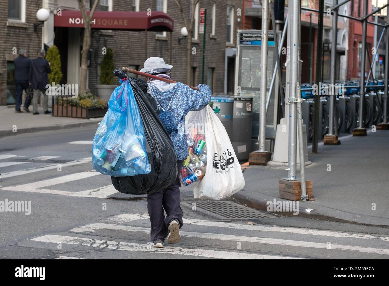 Eine anonyme Frau, die Pfandflaschen und Dosen in Greenwich Village, Manhattan, New York City sammelt. Stockfoto