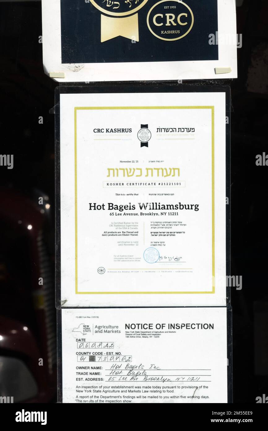 Ein zweisprachiges englisches hebräisches Schild vor DEN HEISSEN BAGELS VON WILLIAMSBURG, das bescheinigt, dass nur koschere Speisen verkauft werden. Auf der Lee Avenue in Williamsburg, Brooklyn, NYC Stockfoto