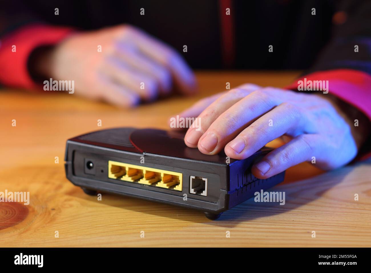 adsl-Modem auf dem Tisch vor der Person im Hintergrund Stockfoto