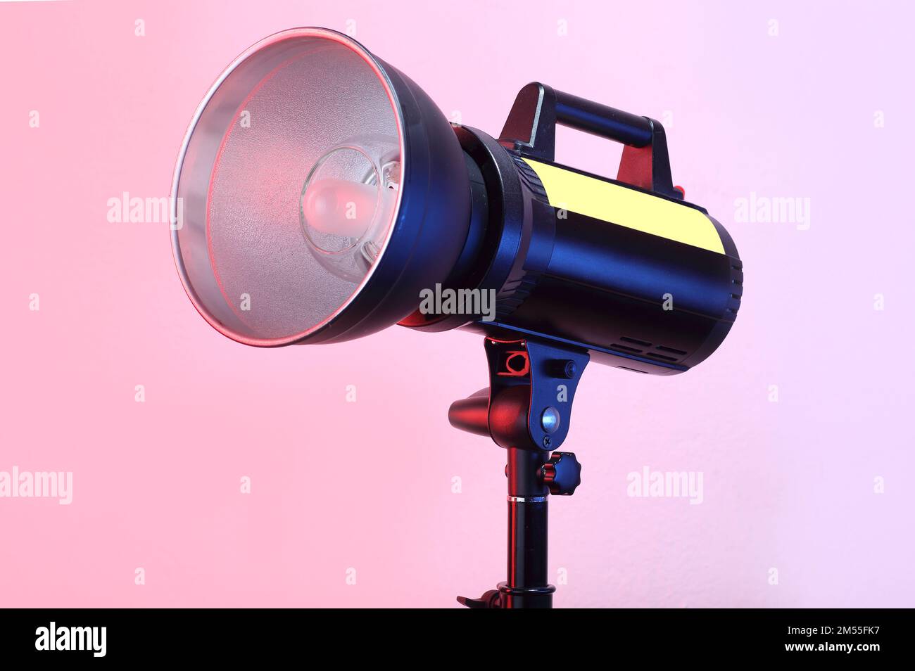 studio-Blitz auf einem Stativ und pinkfarbenem Hintergrund Stockfoto