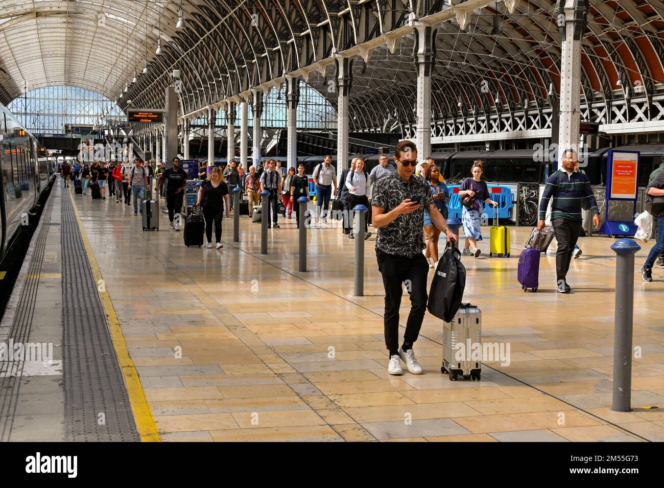 London, England, Vereinigtes Königreich - Juni 2022: Personen, die nach der Ankunft mit dem Zug an einem der Bahnsteige des Londoner Bahnhofs Paddington entlang laufen Stockfoto