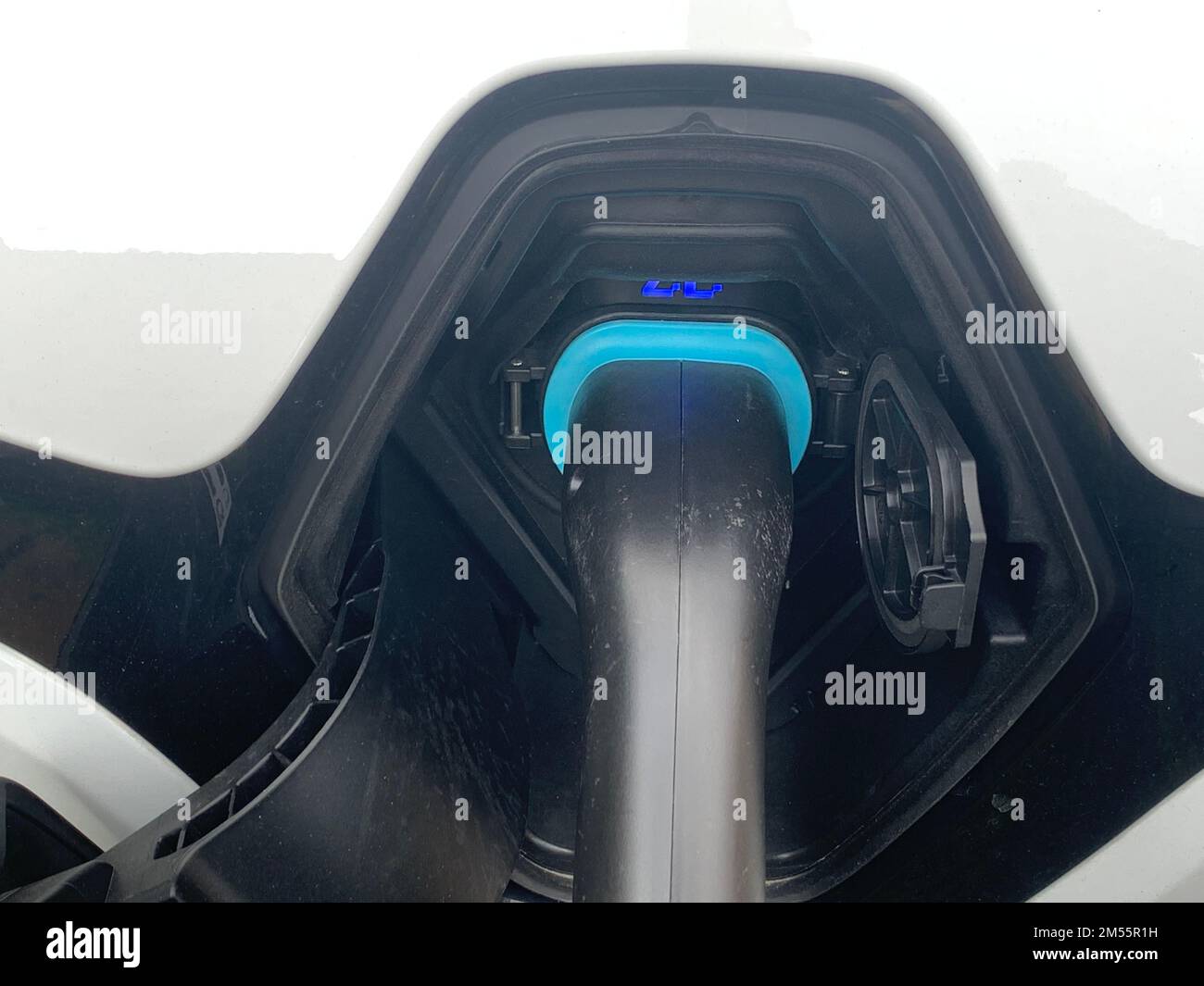 Ladevorrichtung für Elektrofahrzeuge, Elektrofahrzeuge oder Elektrofahrzeuge an der Ladestation mit eingestecktem Netzkabel. Umweltfreundliches Konzept für nachhaltige Energie Stockfoto