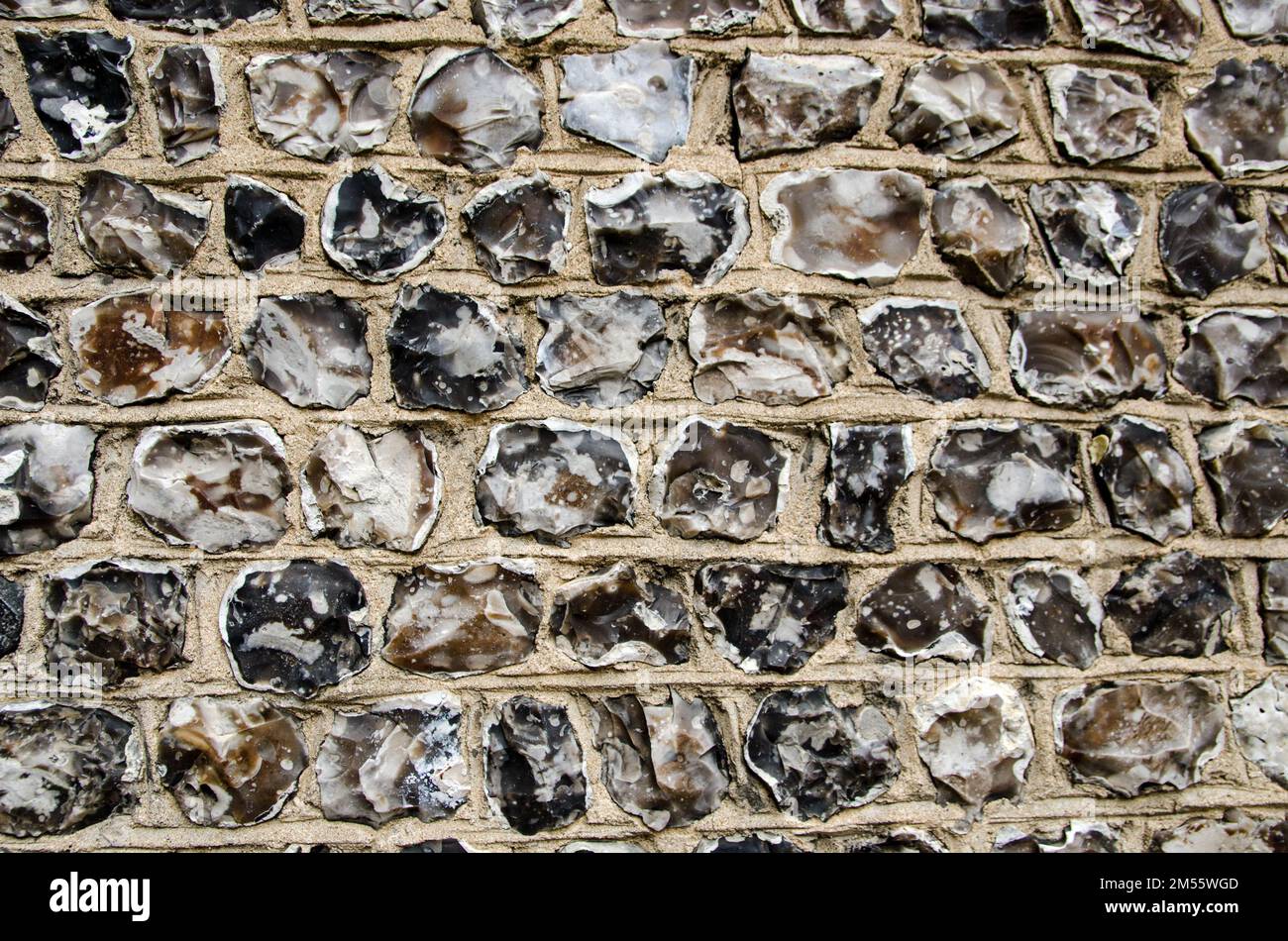 Aus nächster Nähe sehen Sie erschlafene Feuersteine, die eine Mauer im historischen Winchester, Hampshire, bilden. Stockfoto