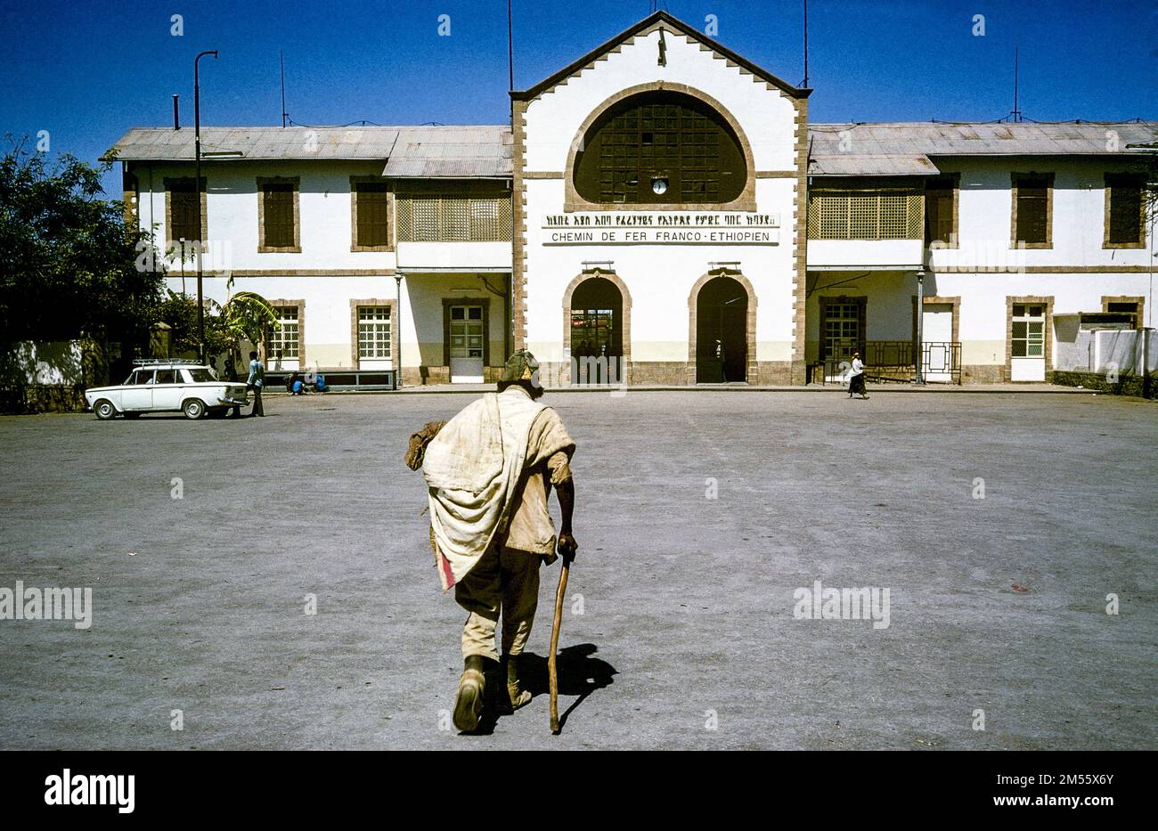 Äthiopien, 1970er, Dre Dawa, Rückansicht eines Mannes, der mit einem Stock läuft, Bahnhof Chemin de Fer Franco-Äthiopien, Dre Dawa Region, Ostafrika, Stockfoto