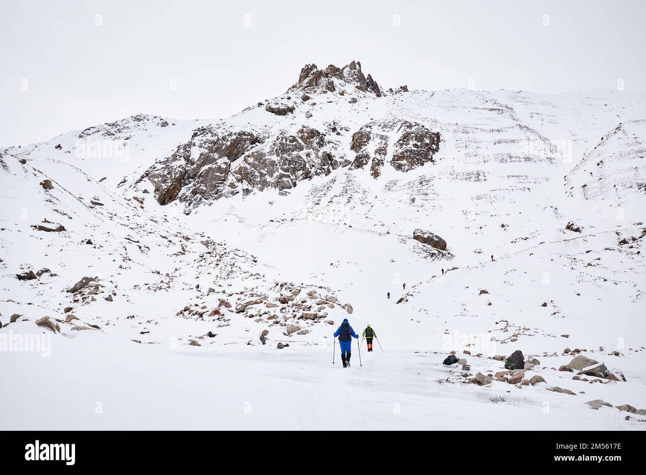 Two Men mit Rucksack auf blauem Eisgletscher in der wunderschönen Landschaft des schneebedeckten Bergtals in Almaty, Kasachstan Stockfoto