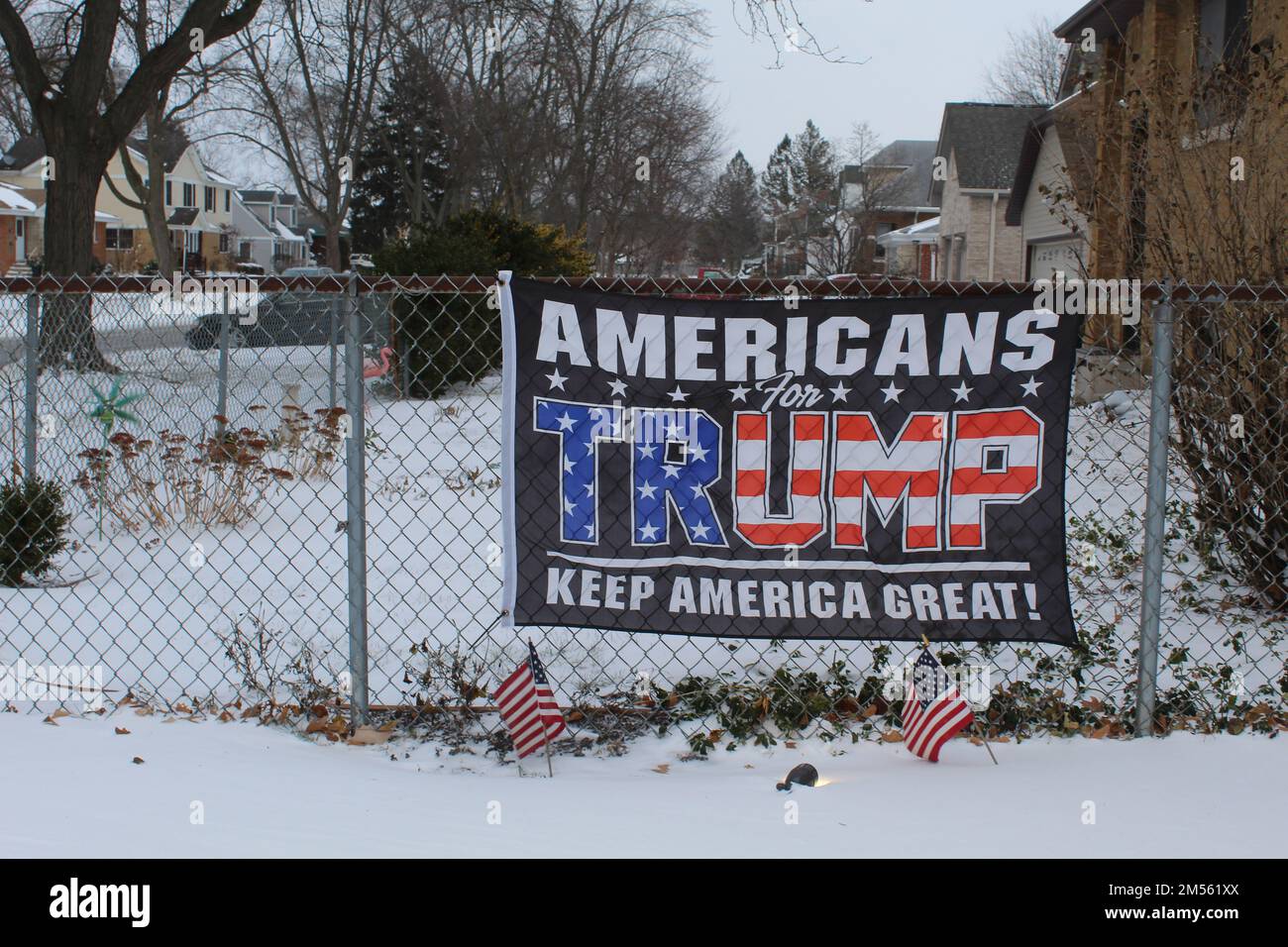Amerikaner für Trump halten das amerikanische Banner auf einem Zaun mit Snow des Plaines, Illinois Stockfoto