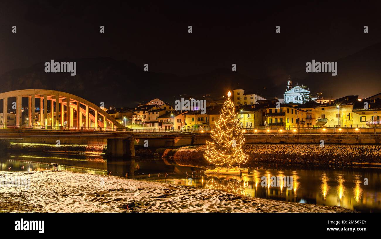 San Michele all'Adige in der Provinz Trient: Der große Weihnachtsbaum am Fluss Adige, Nachtfotografie - Trentino Alto Adige - Italien - Europa Stockfoto