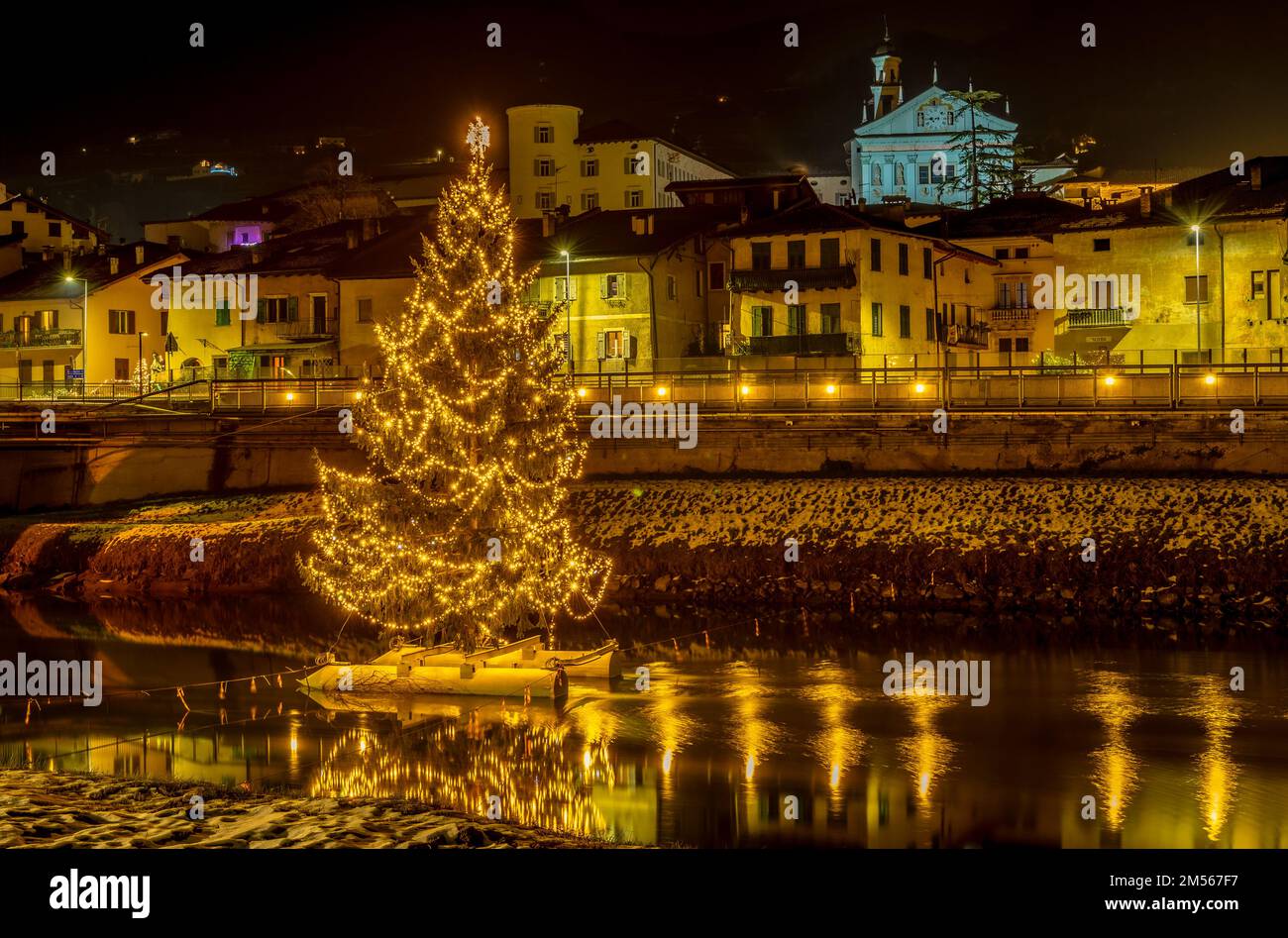 San Michele all'Adige in der Provinz Trient: Der große Weihnachtsbaum am Fluss Adige, Nachtfotografie - Trentino Alto Adige - Italien - Europa Stockfoto