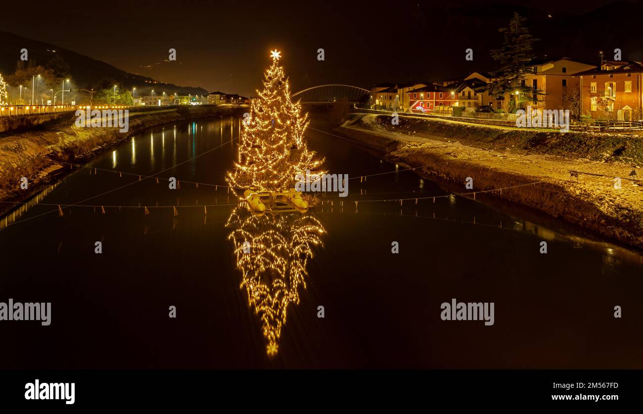 Der große Weihnachtsbaum an der Etsch - San Michele all'Adige in der Provinz Trient. Nachtfotografie. Stockfoto