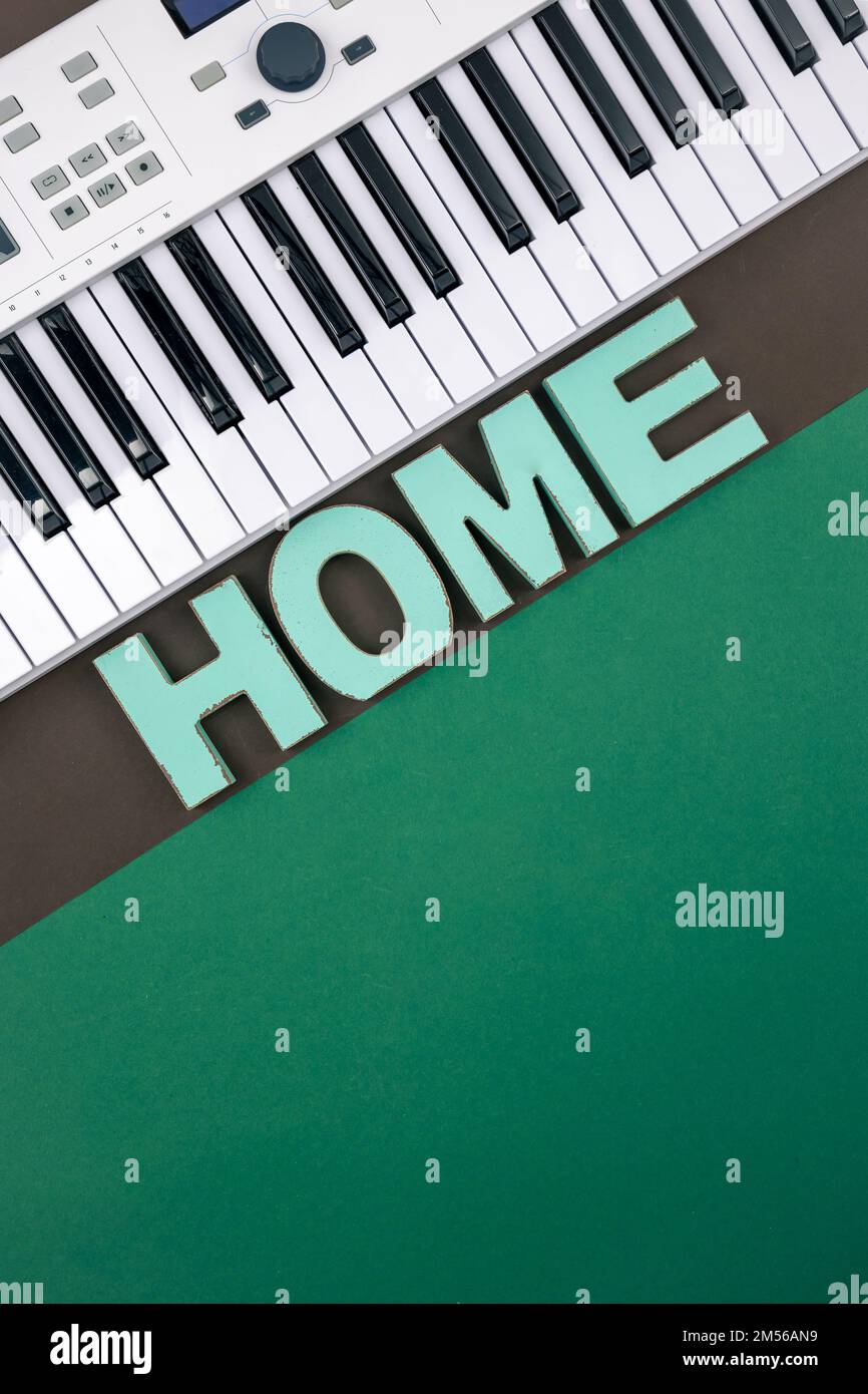 Musikalische Tasten und dekoratives Wort Zuhause auf einem farbigen Hintergrund. Stockfoto