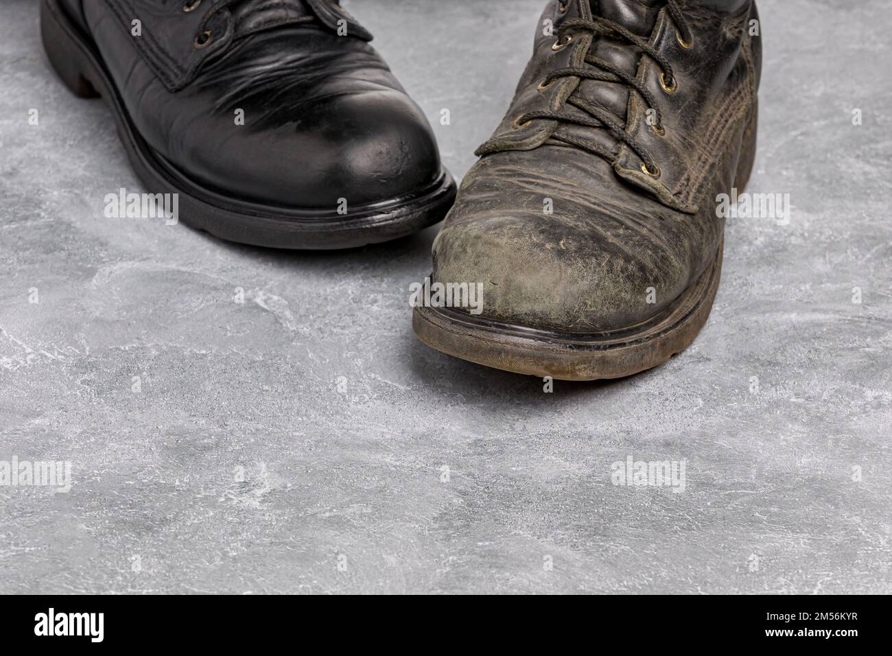 Vor und nach polierten und schmutzigen Arbeitsstiefeln aus Leder. Schuhcreme, Schuhpflege und -Reinigung. Stockfoto