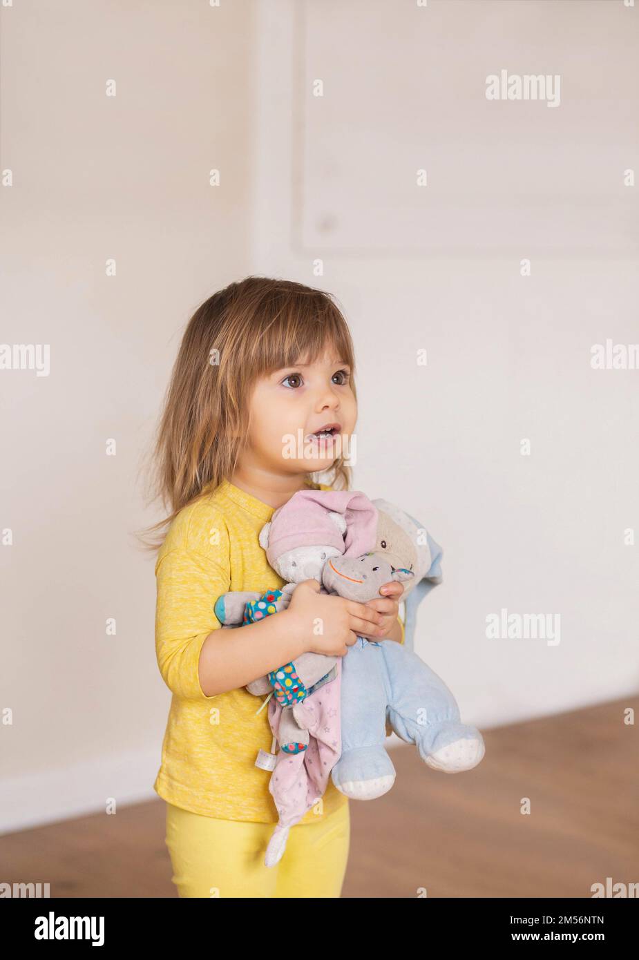 Bezauberndes Baby, das weiche Spielzeuge umarmt. Platz für Text Stockfoto