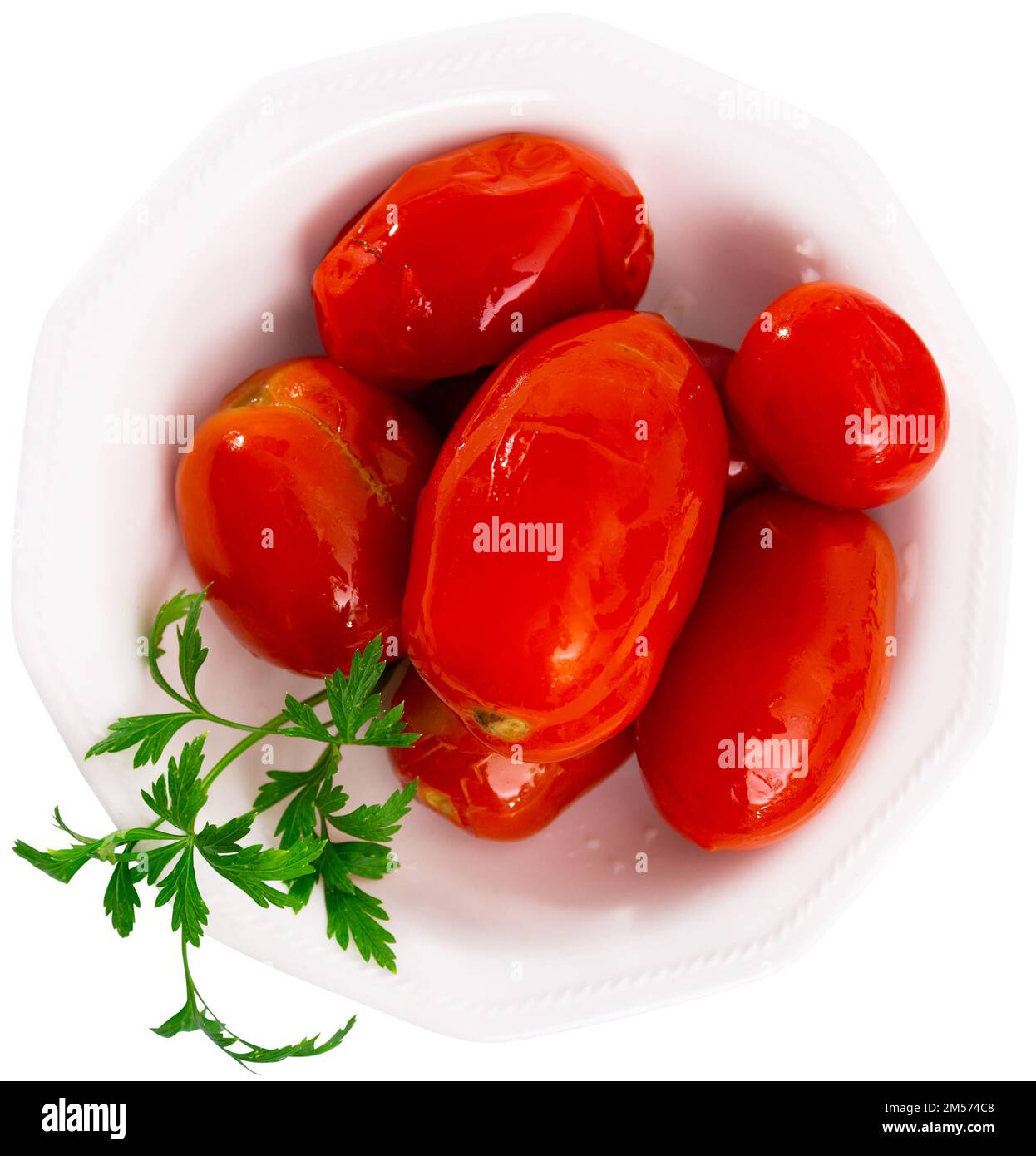 Saftige marinierte Tomaten, serviert auf einem mit Parsle dekorierten Teller. Hausgemachte Konserven. Eingelegtes Gemüse Stockfoto