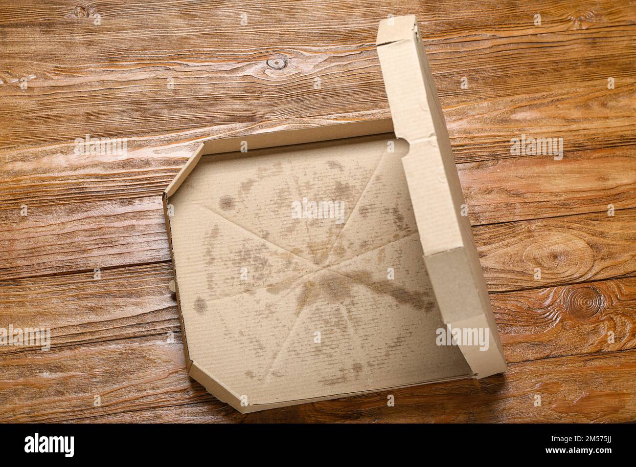 Leere fettige Pizzaschachtel auf Holzhintergrund Stockfoto