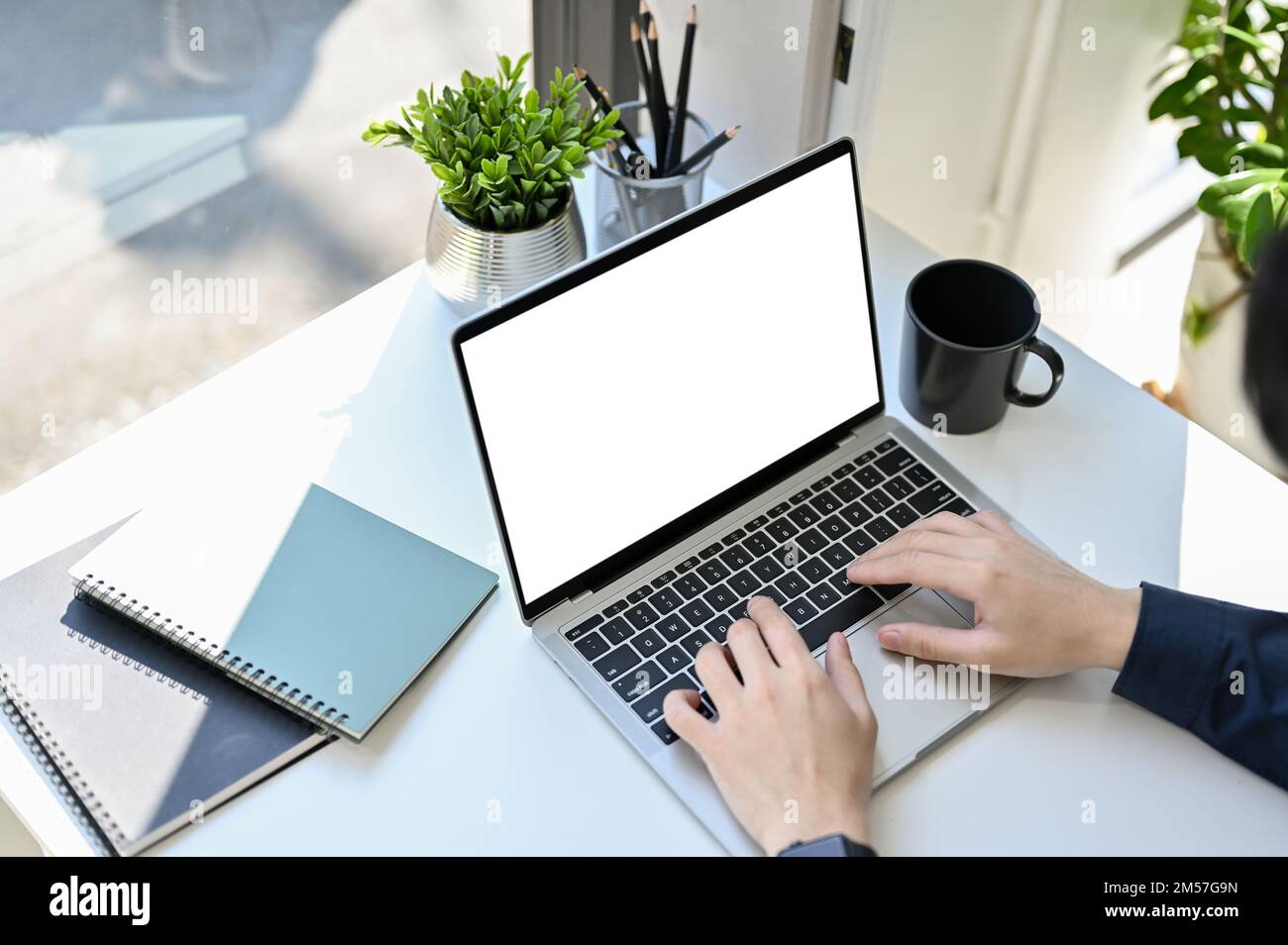 Draufsicht, professioneller Geschäftsmann oder männlicher Büroangestellter, der einen Laptop verwendet, auf seinem Schreibtisch eine Notebook-Tastatur eingibt. Notebook-Whitescreen Mo Stockfoto