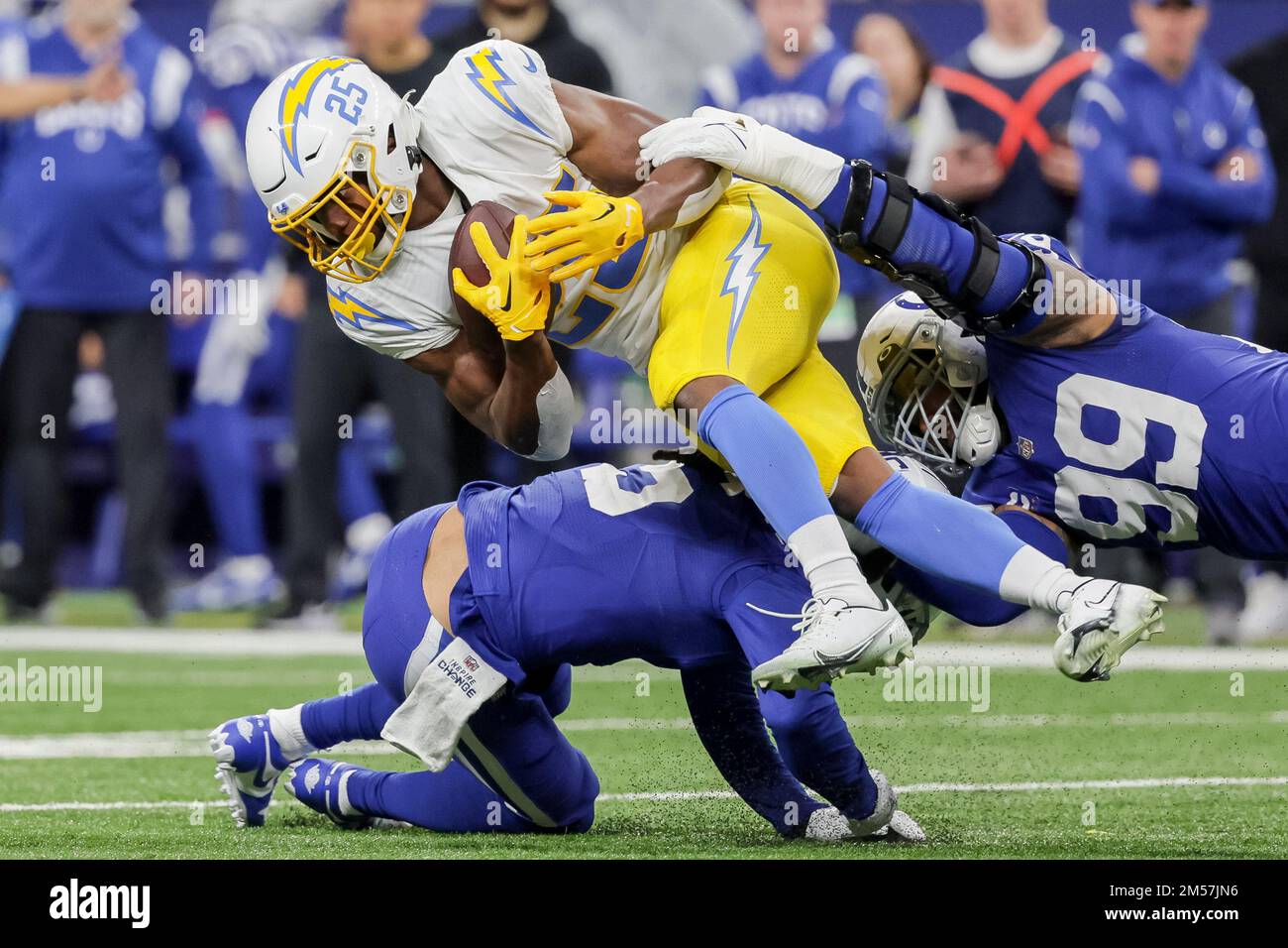 Indianapolis, Indiana, USA. 26. Dezember 2022. Los Angeles Chargers Running Back Joshua Kelley (25) trägt den Ball und wird vom Indianapolis Colts Defensive Tackle DeForest Buckner (99) während des Spiels zwischen den Los Angeles Chargers und den Indianapolis Colts im Lucas Oil Stadium, Indianapolis, Indiana, angegriffen. (Kreditbild: © Scott Stuart/ZUMA Press Wire) Kredit: ZUMA Press, Inc./Alamy Live News Stockfoto