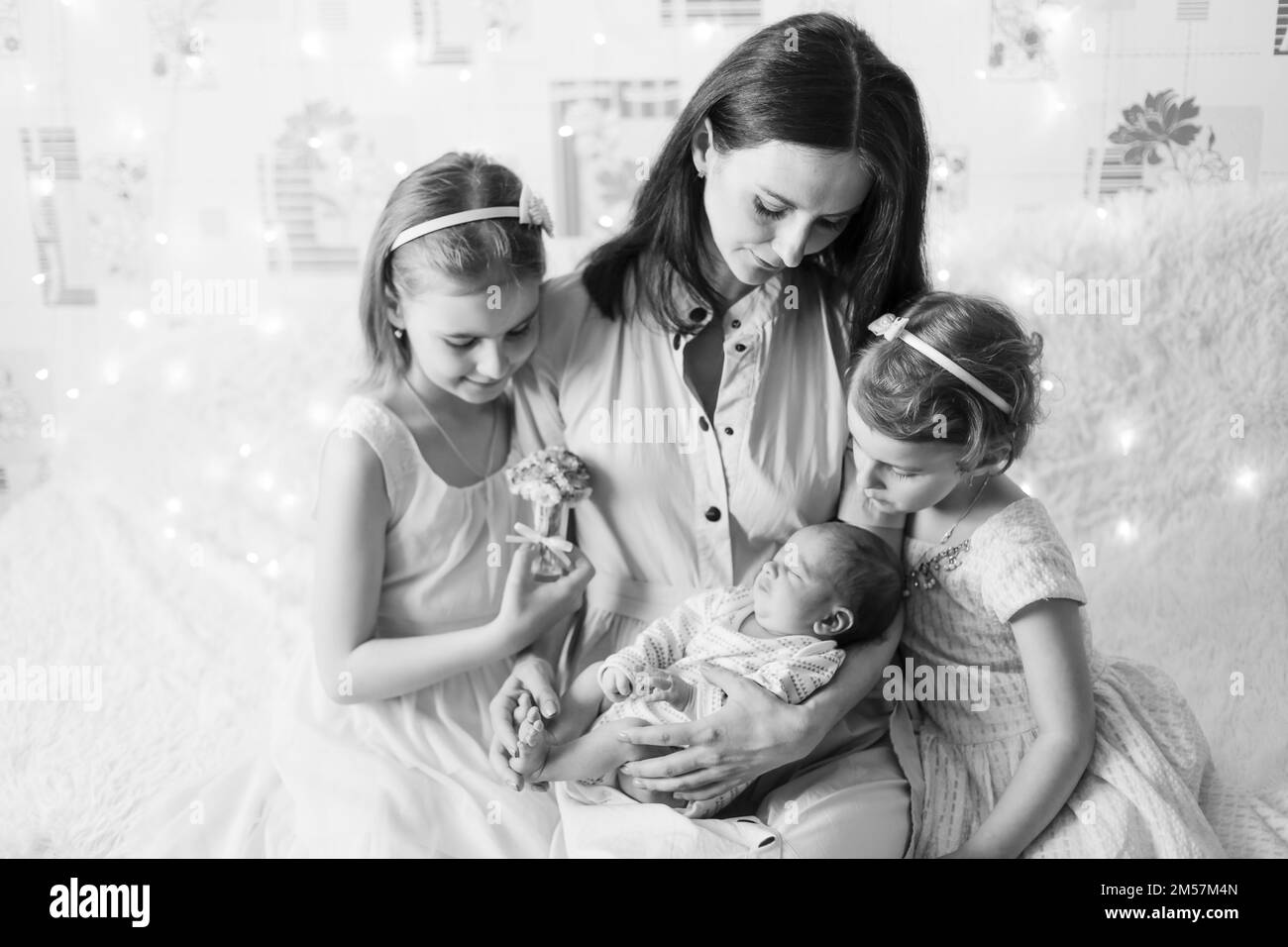 Porträt einer glücklichen Mutter mit drei Kindern. Schwarzweißfoto Stockfoto