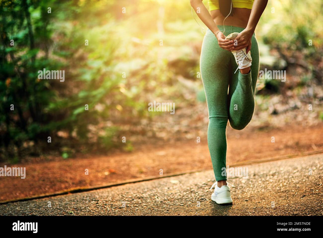 Stretching kann dir so viel Gutes tun. Eine junge Frau, die sich vor ihrem Lauf dehnt. Stockfoto