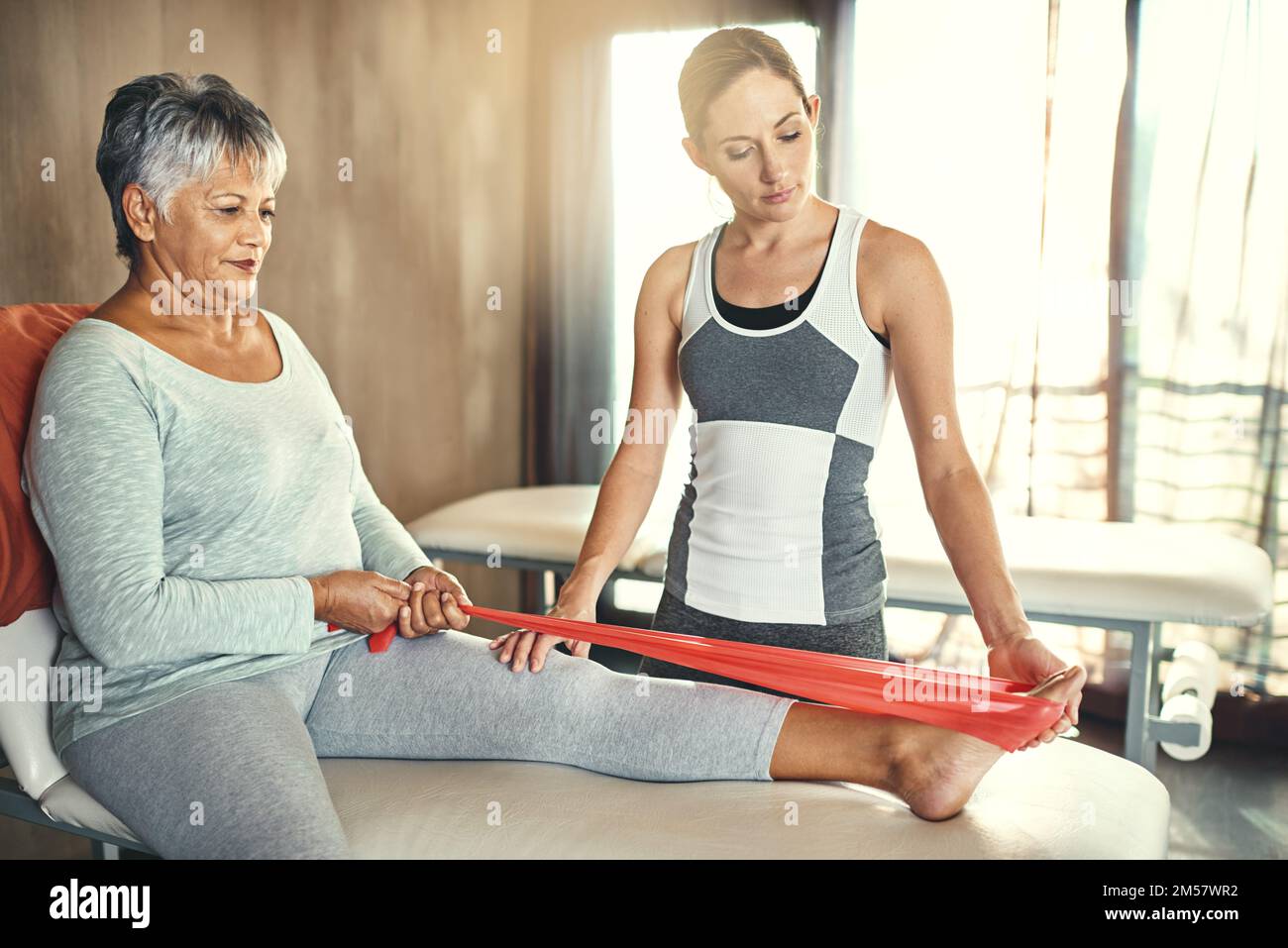 Ich werde dafür sorgen, dass Sie so unabhängig wie möglich bleiben. Eine ältere Frau, die von einem Physiotherapeuten behandelt wird. Stockfoto