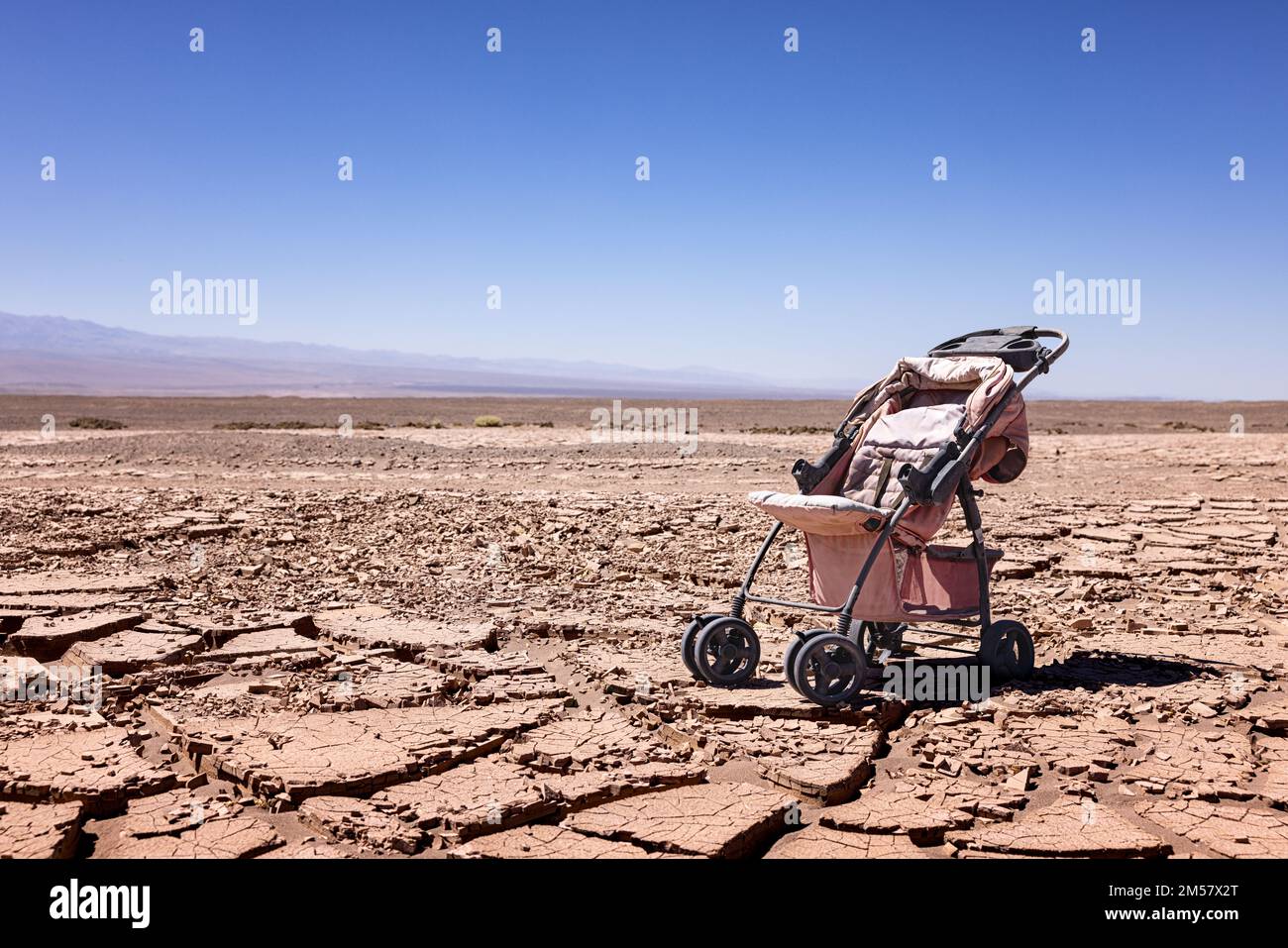 Wüstenbildung: Symbolisches Bild für den Klimawandel - verlassener Kinderwagen auf trockenem Boden in der Atacama-Wüste in der Nähe der Oase Pica Stockfoto