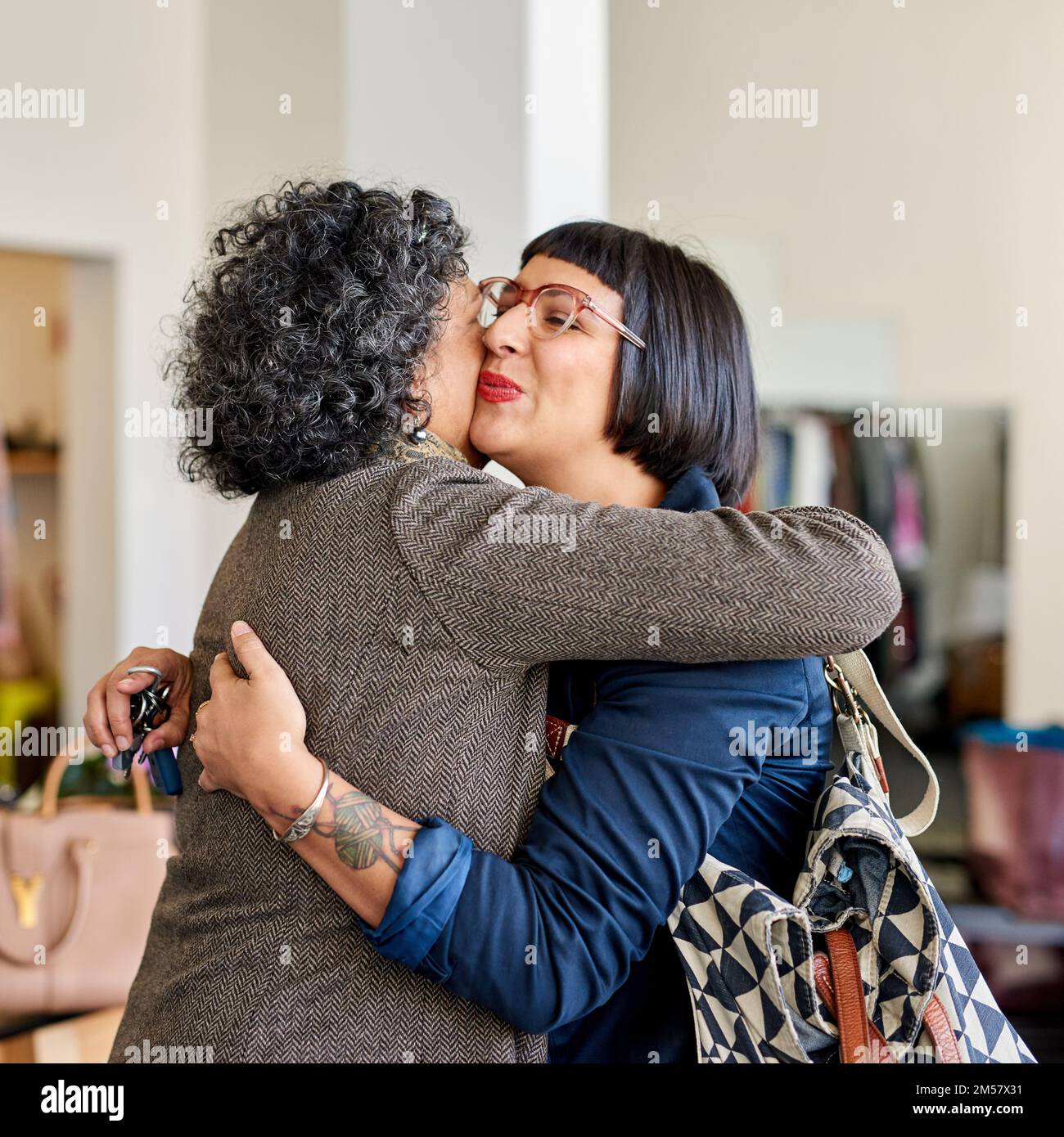 Ich genieße einen Tag mit mom. Eine Mutter und ihre Erwachsene Tochter umarmen sich, während sie zusammen einkaufen. Stockfoto